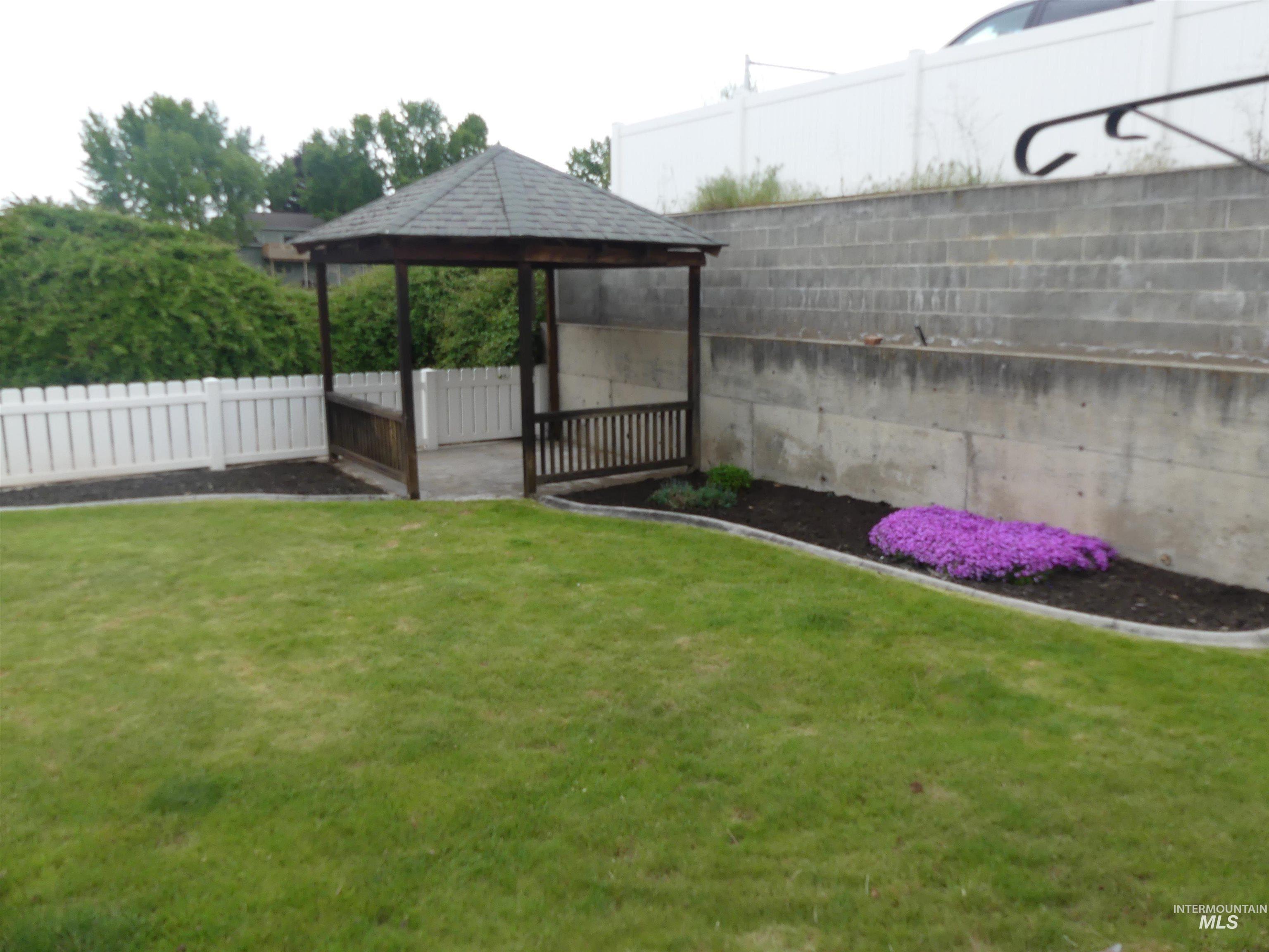 Fenced backyard featuring a gazebo and a patio
