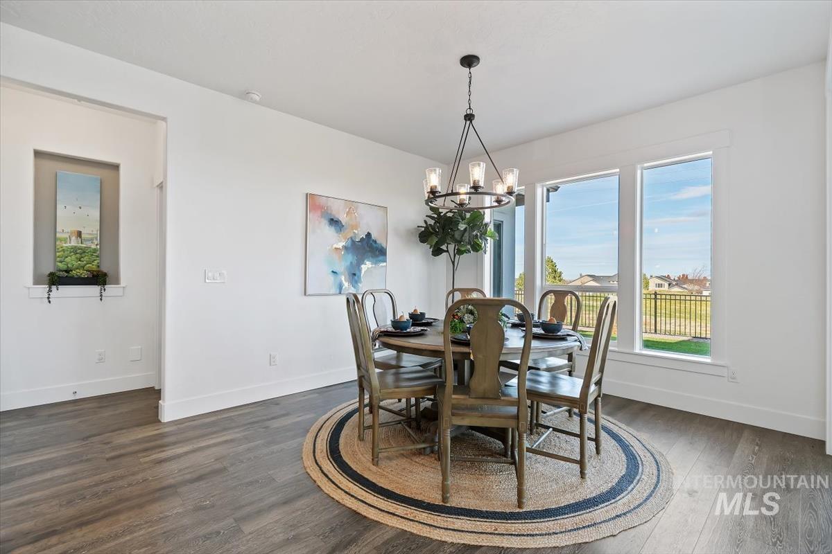 Dining space featuring dark wood finished floors and a chandelier