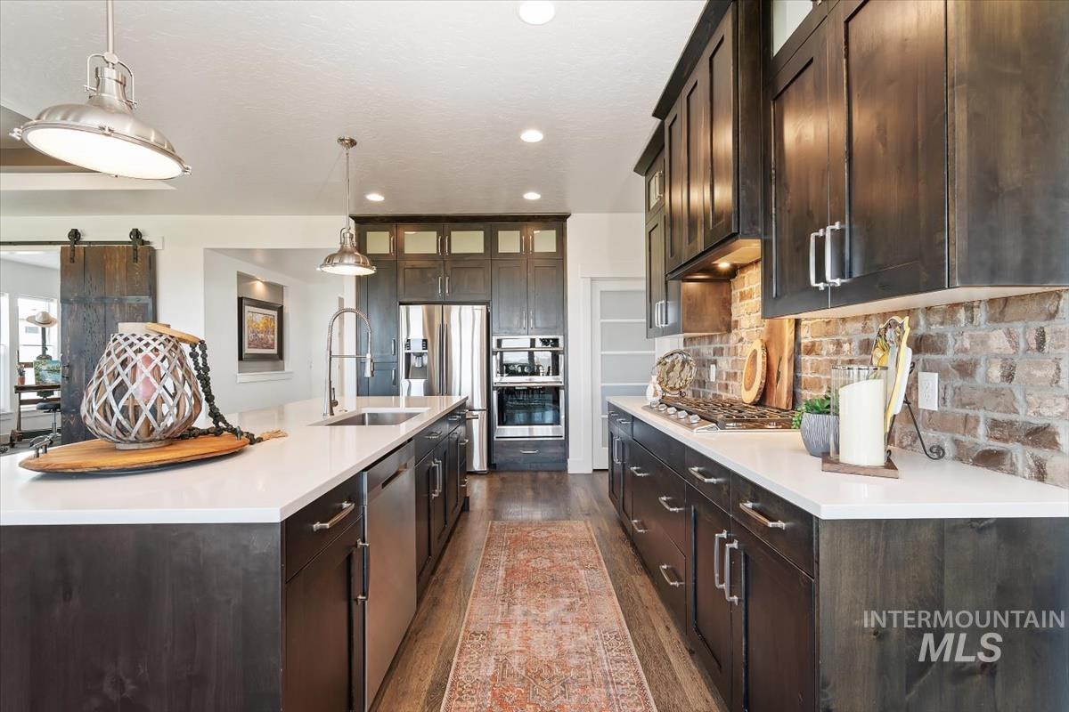 Kitchen with dark brown cabinetry, glass insert cabinets, and recessed lighting