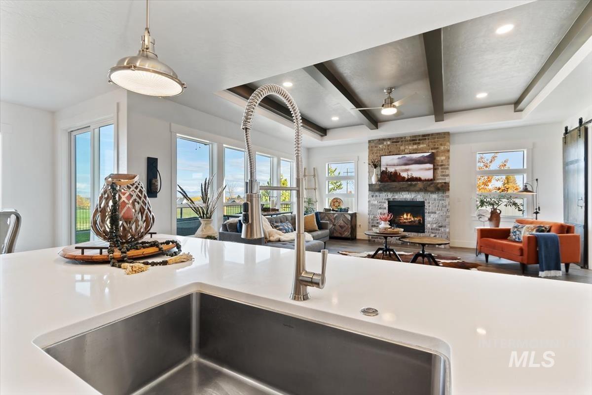 Kitchen featuring plenty of natural light, a tray ceiling, a barn door, beam ceiling, and recessed lighting