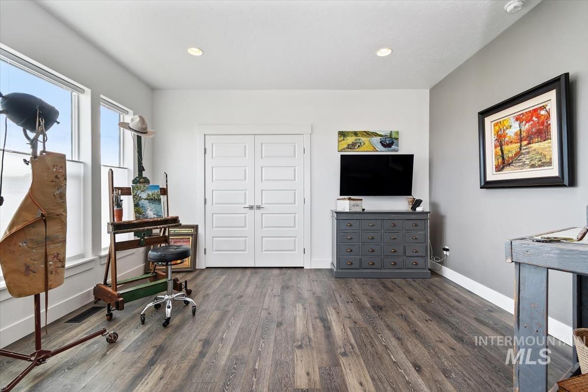 Home office featuring dark wood-style floors and recessed lighting
