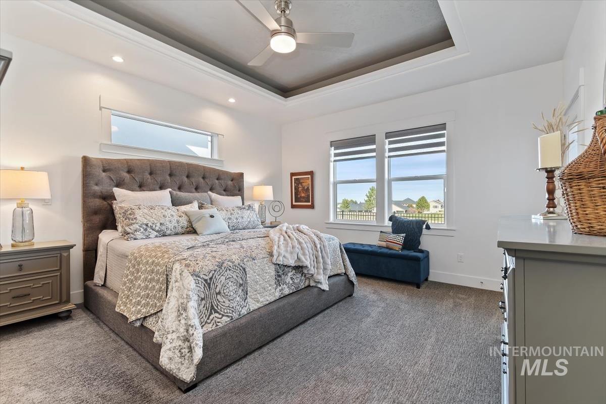 Bedroom featuring a raised ceiling, carpet floors, ceiling fan, and recessed lighting
