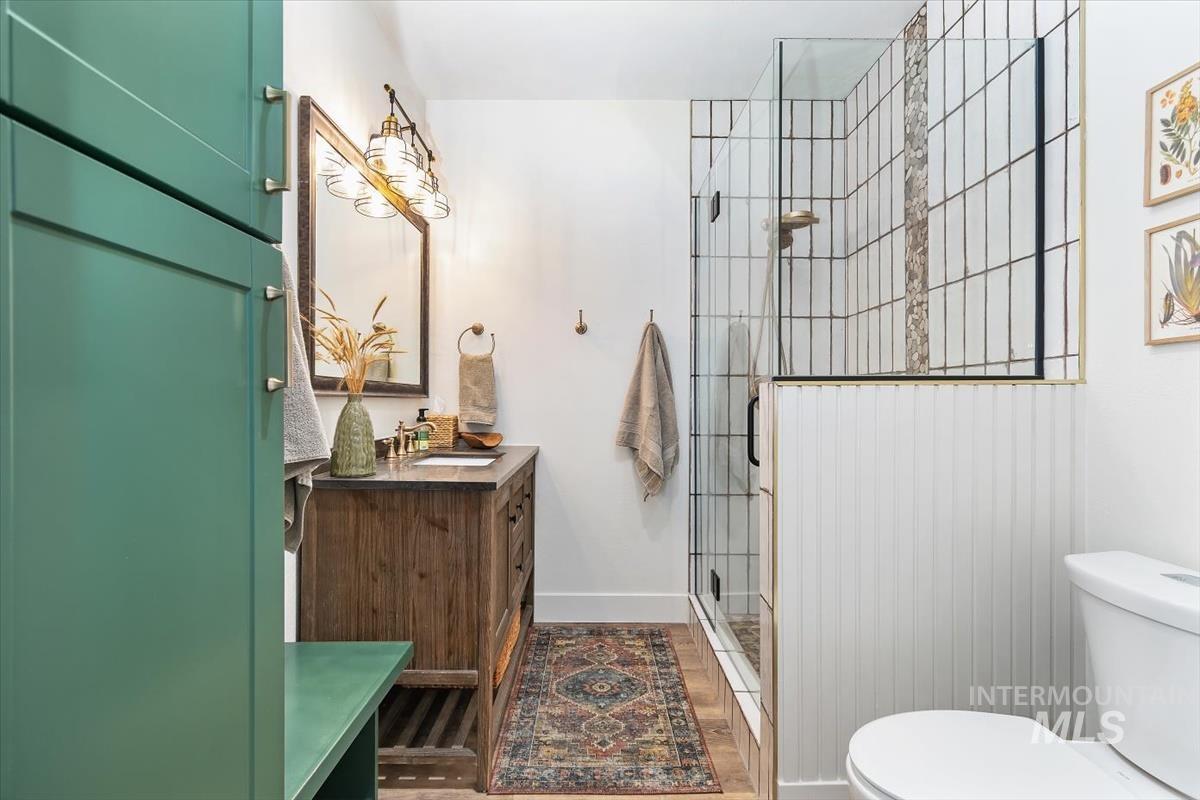 Bathroom with vanity, a stall shower, and dark wood finished floors