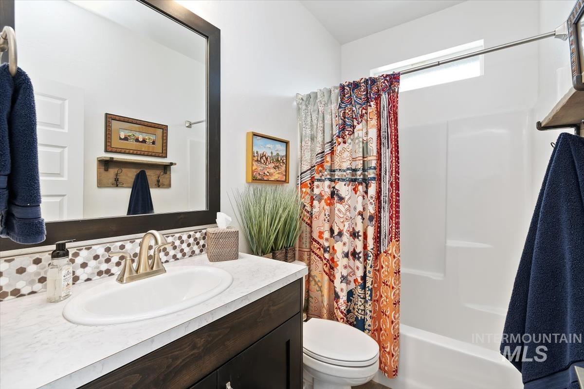 Full bath featuring vanity and shower / bath combo with shower curtain