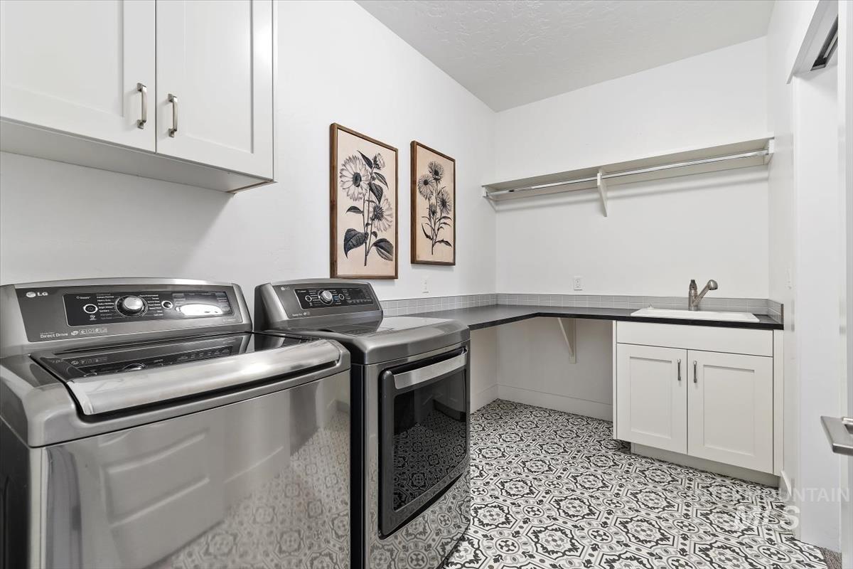 Washroom featuring cabinet space, independent washer and dryer, and a textured ceiling