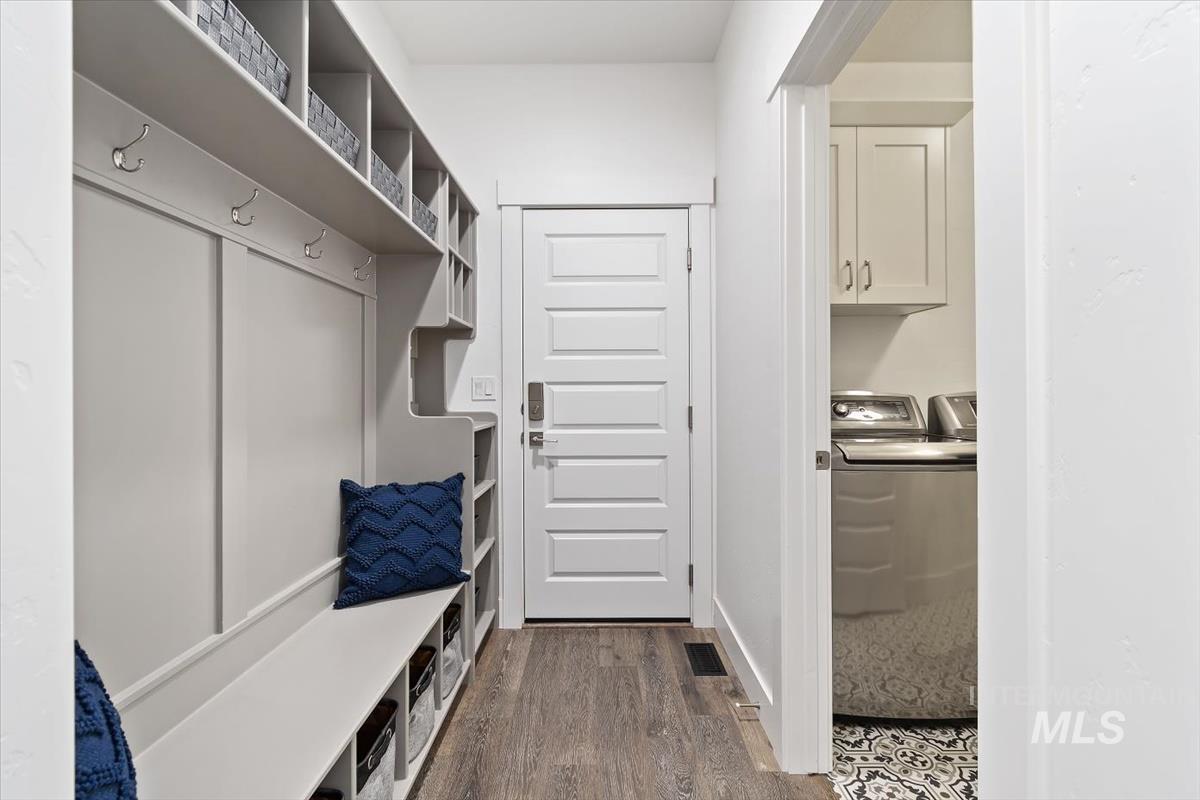 Mudroom with dark wood-style flooring and washing machine and clothes dryer