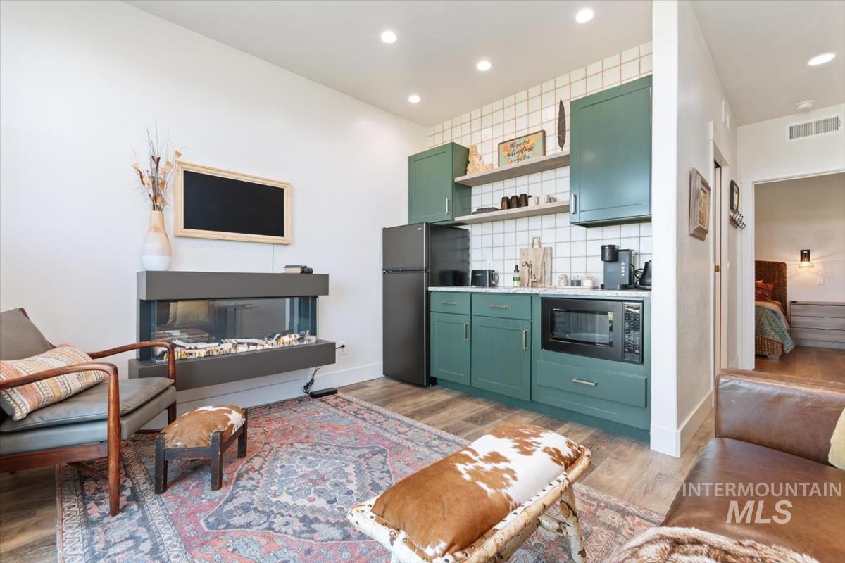 Living area with light wood-style floors and recessed lighting