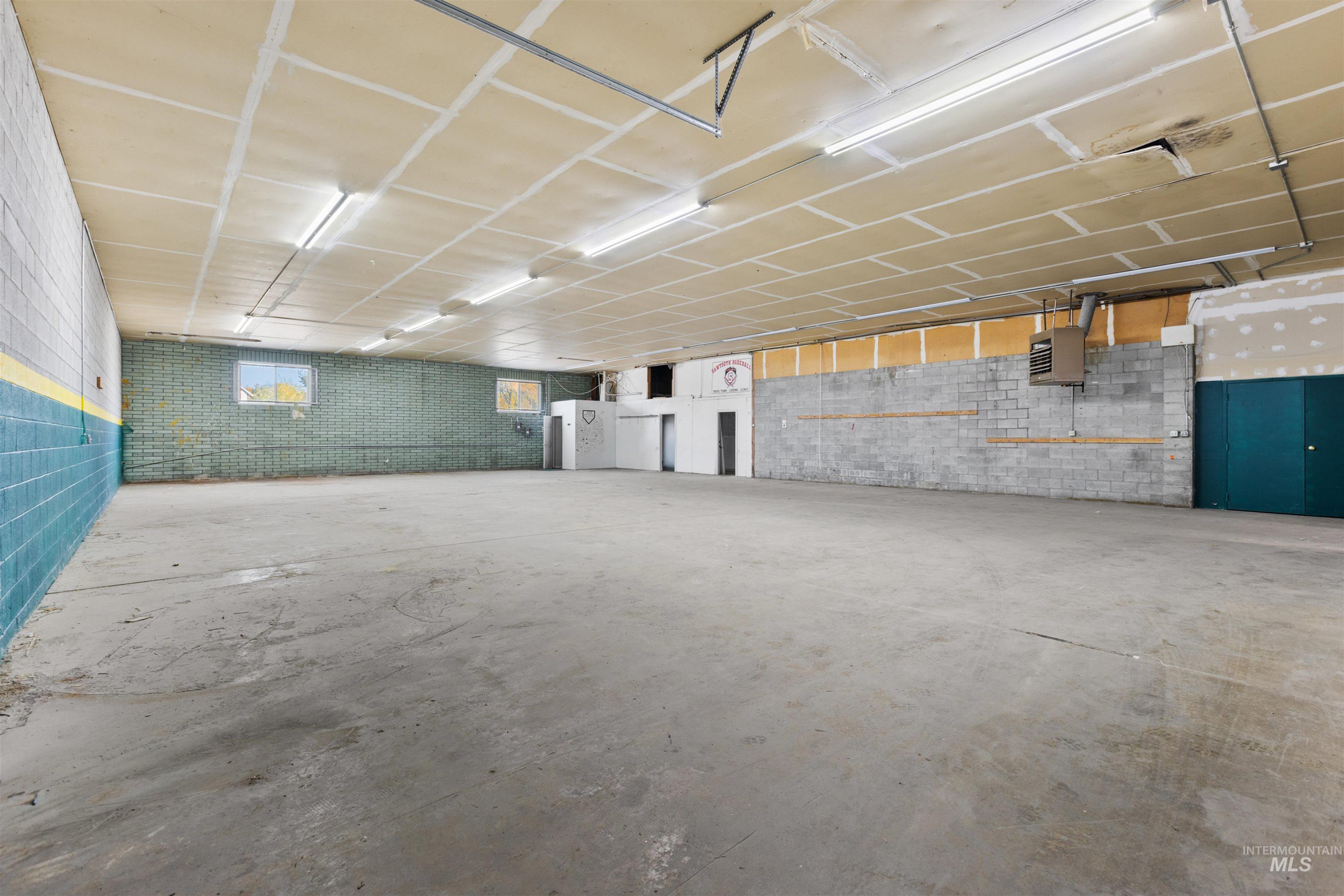 Basement featuring concrete block wall, a heating unit, and a garage