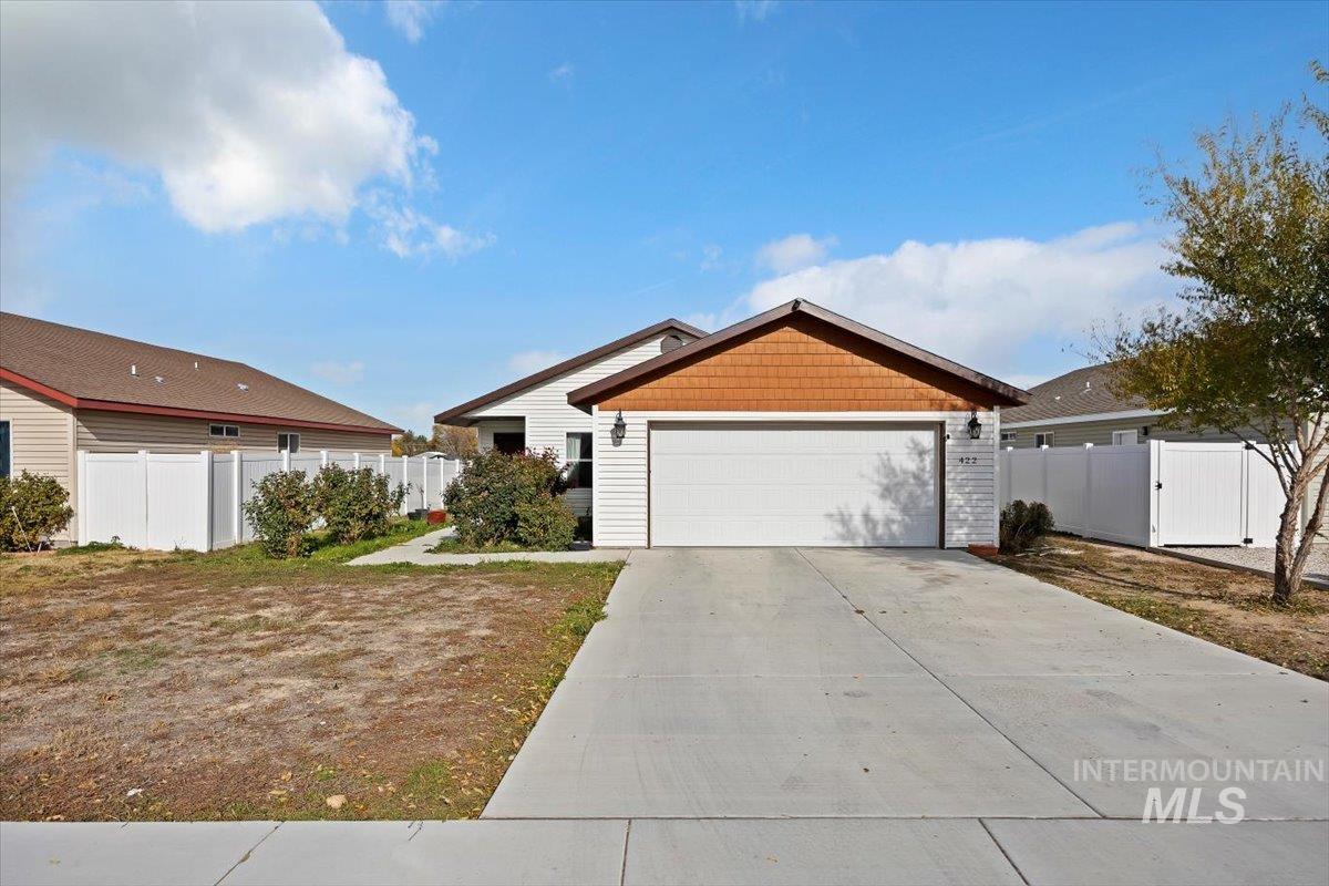 View of front facade with a gate and concrete driveway