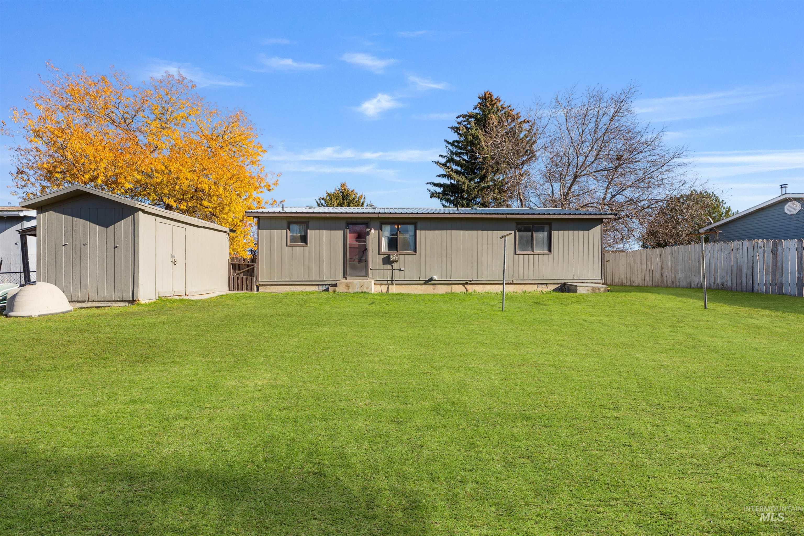 View of front of home with a storage unit and a metal roof