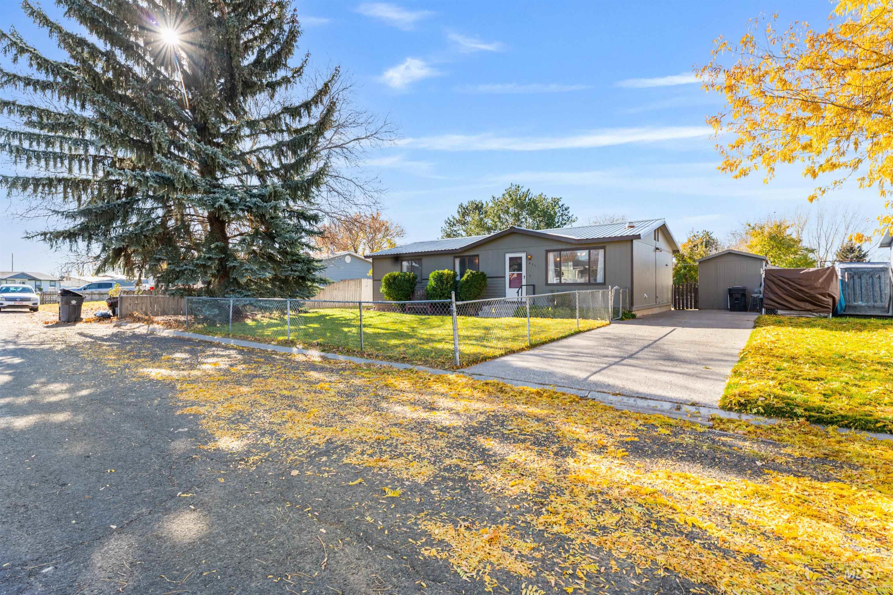View of front facade with a metal roof and a fenced front yard