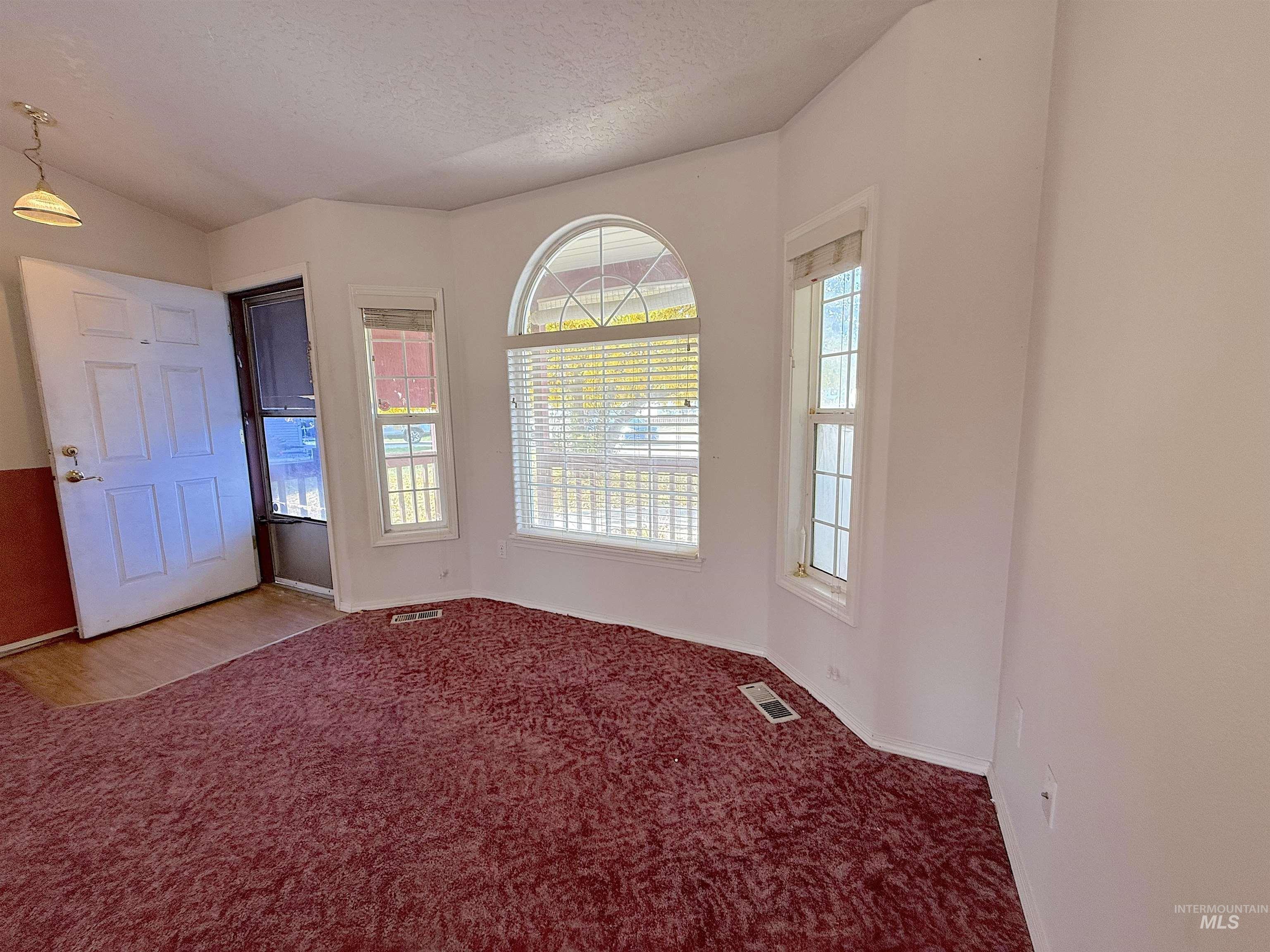 Spare room with carpet floors and a textured ceiling
