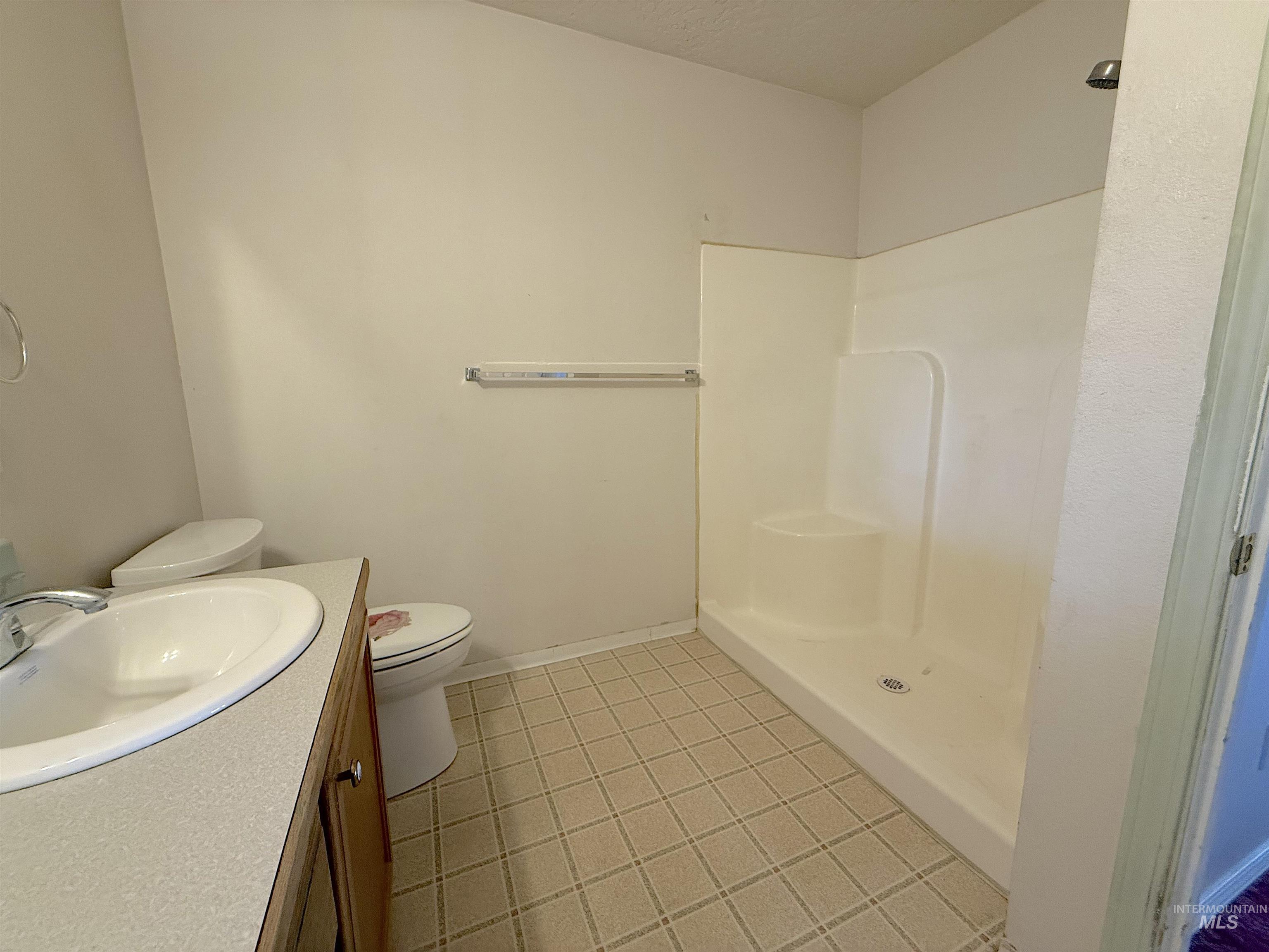 Bathroom featuring vanity, a shower stall, light tile patterned floors, and a textured ceiling