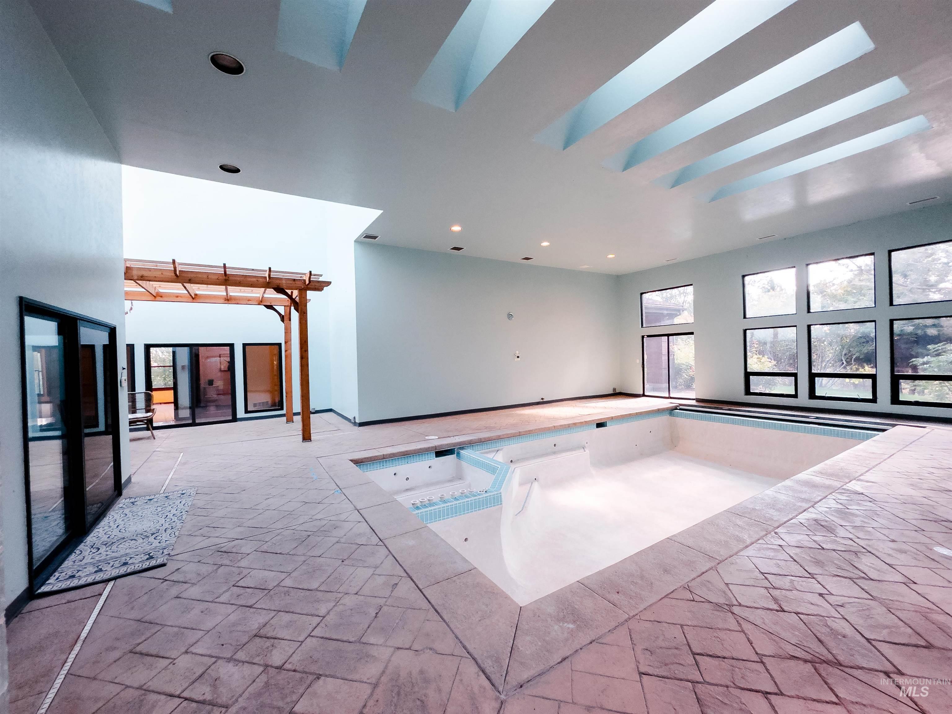 View of pool with a pool with connected hot tub and a skylight