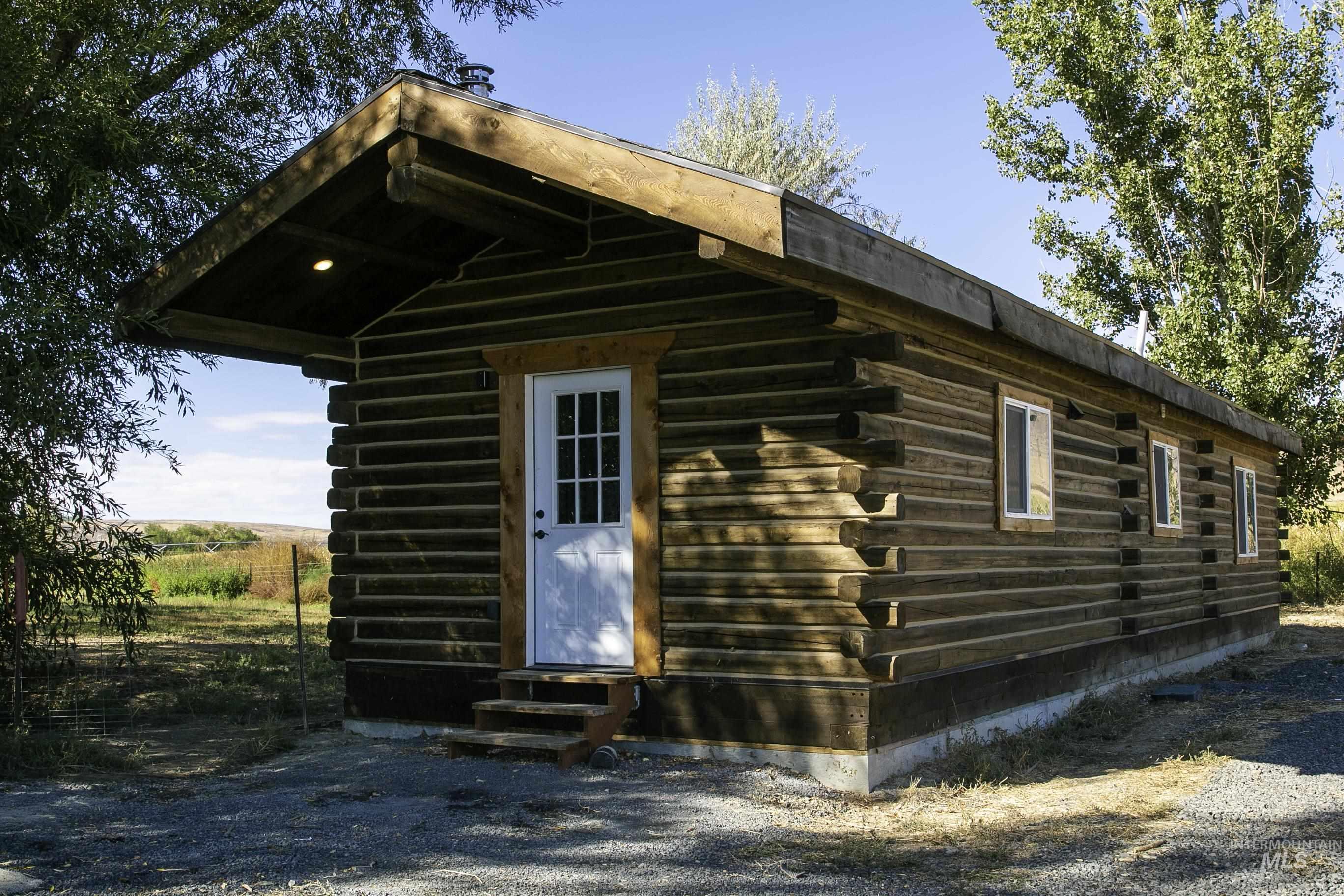 View of side of property featuring log exterior, entry steps, and an outdoor structure