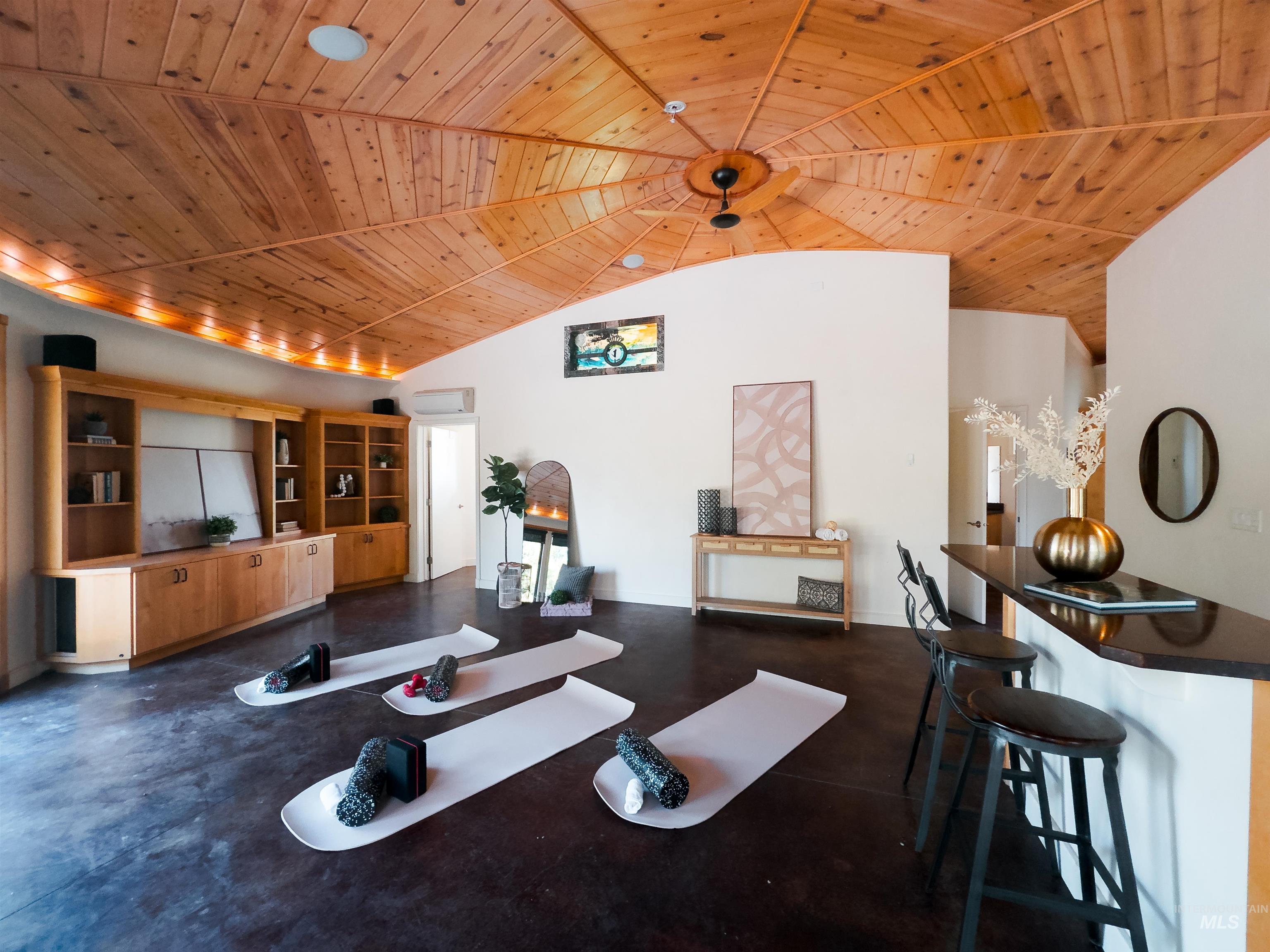 Workout room with wood ceiling and high vaulted ceiling