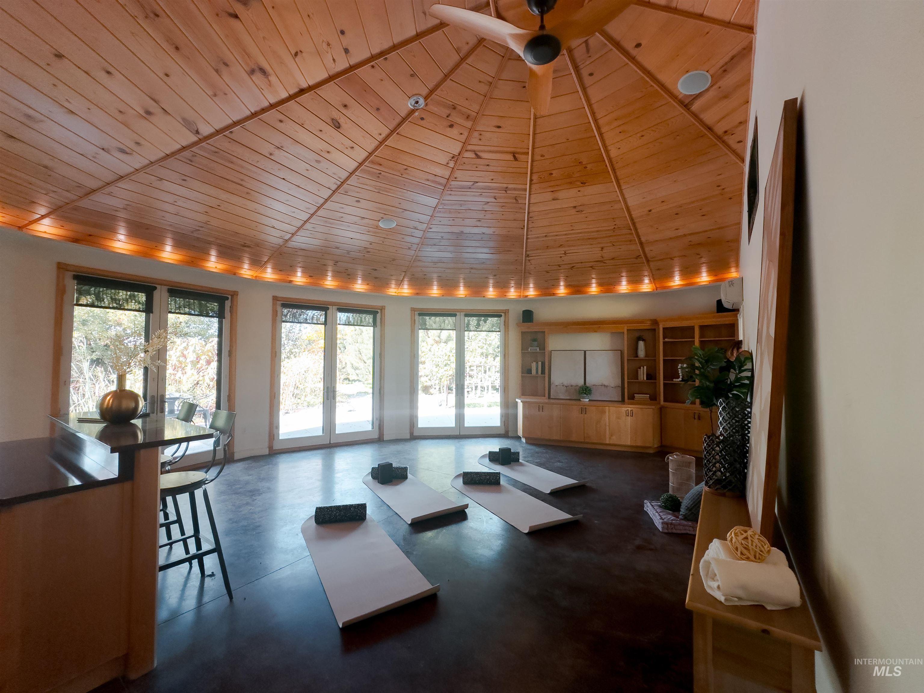 Workout room featuring wood ceiling and finished concrete flooring