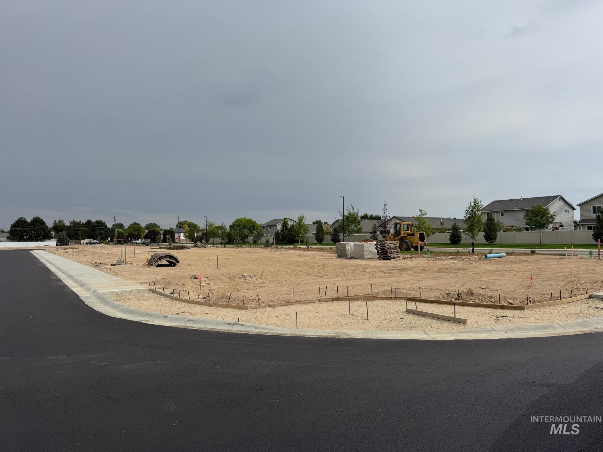 View of asphalt road featuring curbs and a residential view