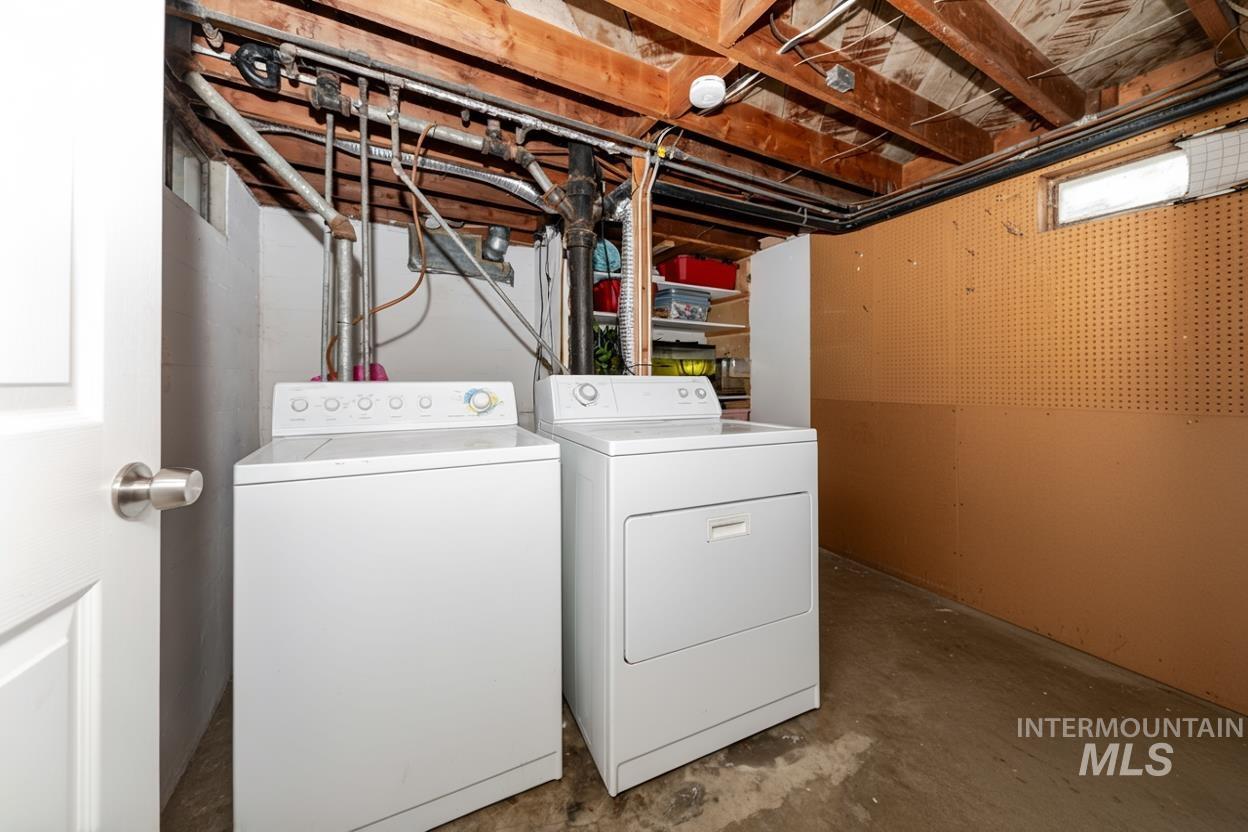 Washroom with concrete floors and washer and dryer