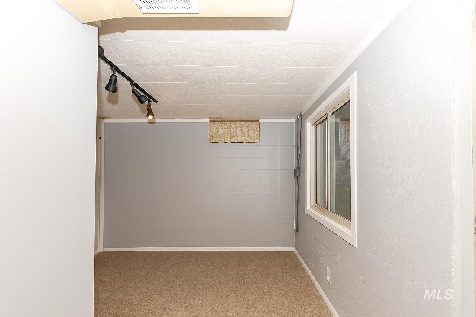 Hallway featuring rail lighting and light carpet