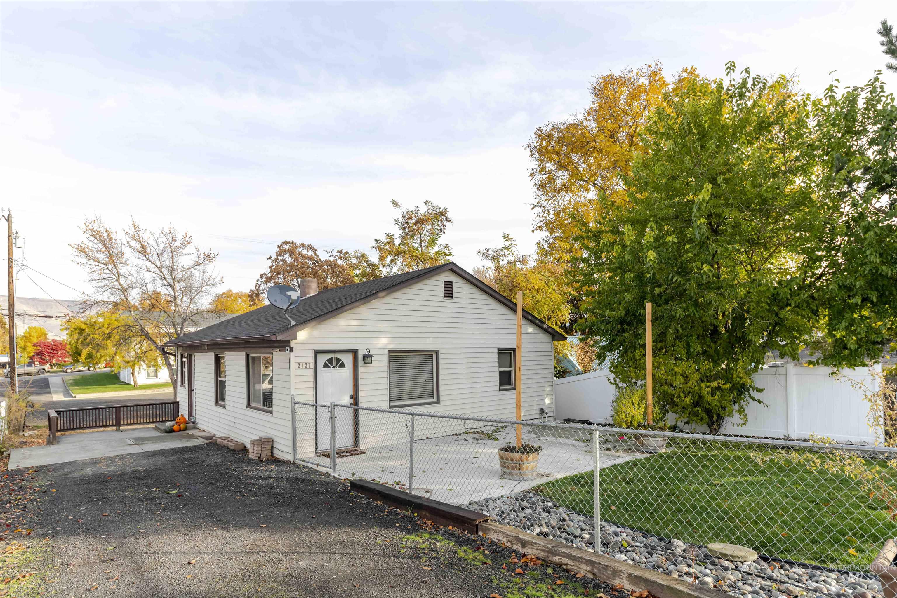 View of front of house with a fenced backyard and a chimney