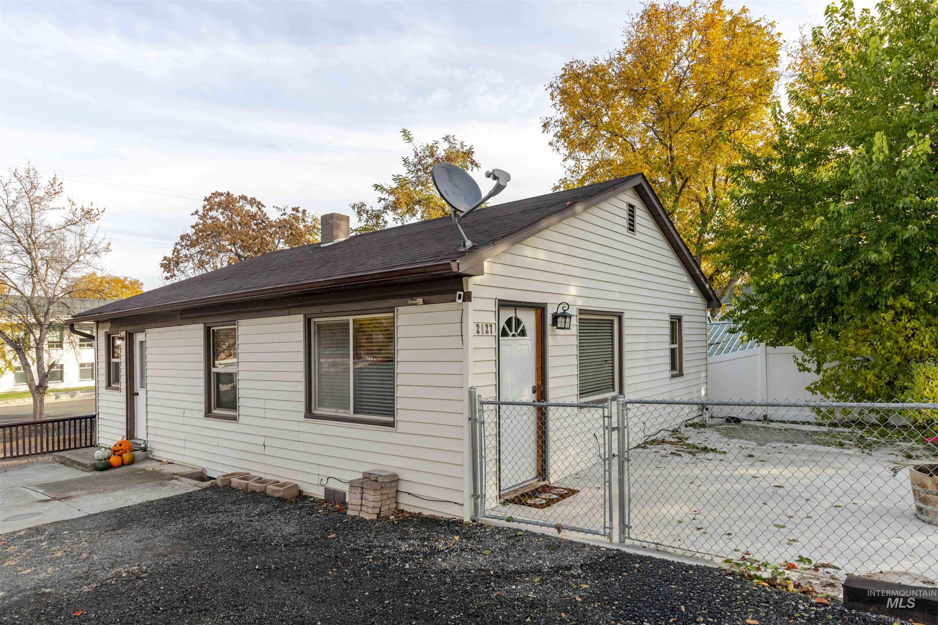Back of house featuring a chimney and a gate