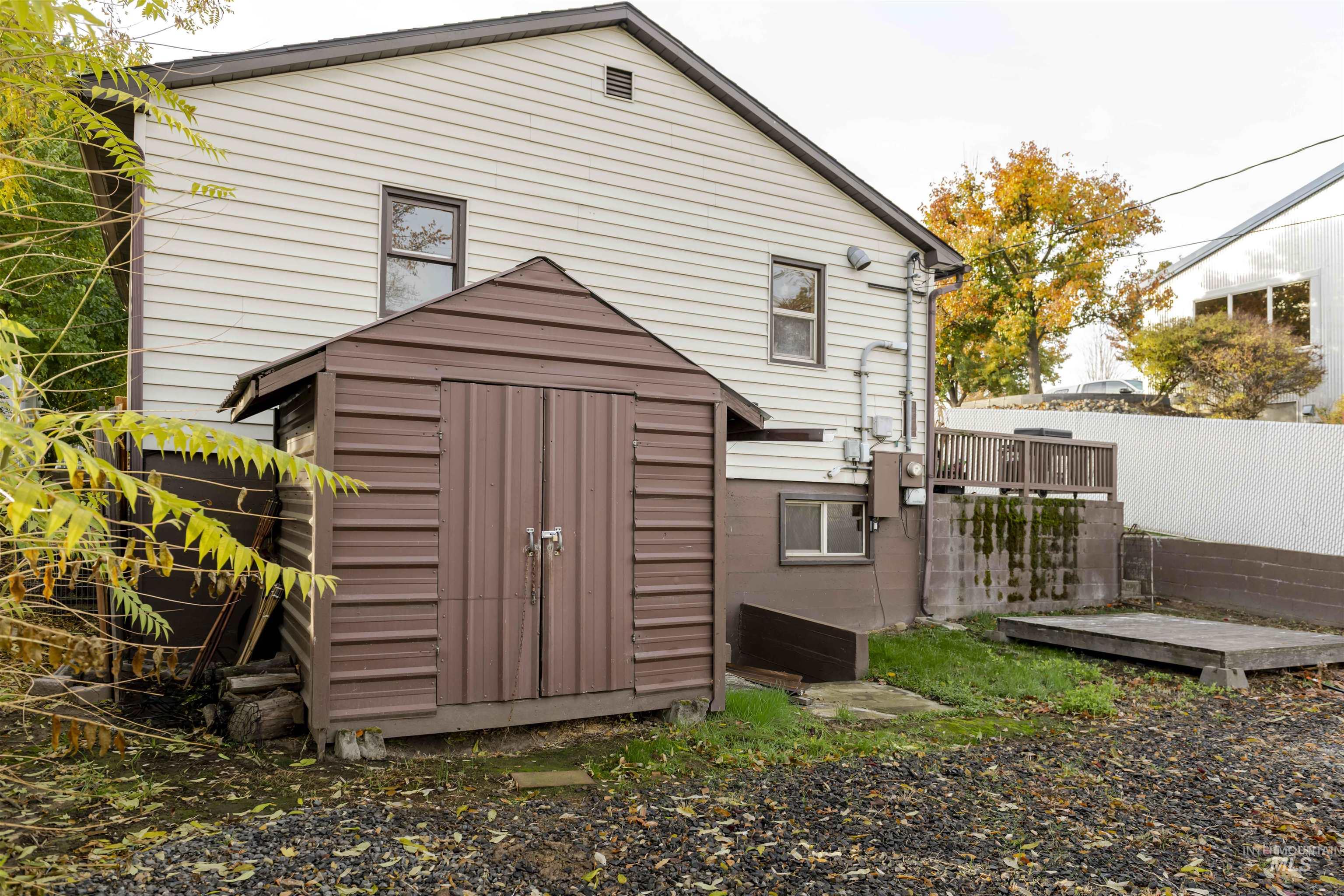 Back of house with a shed and a wooden deck