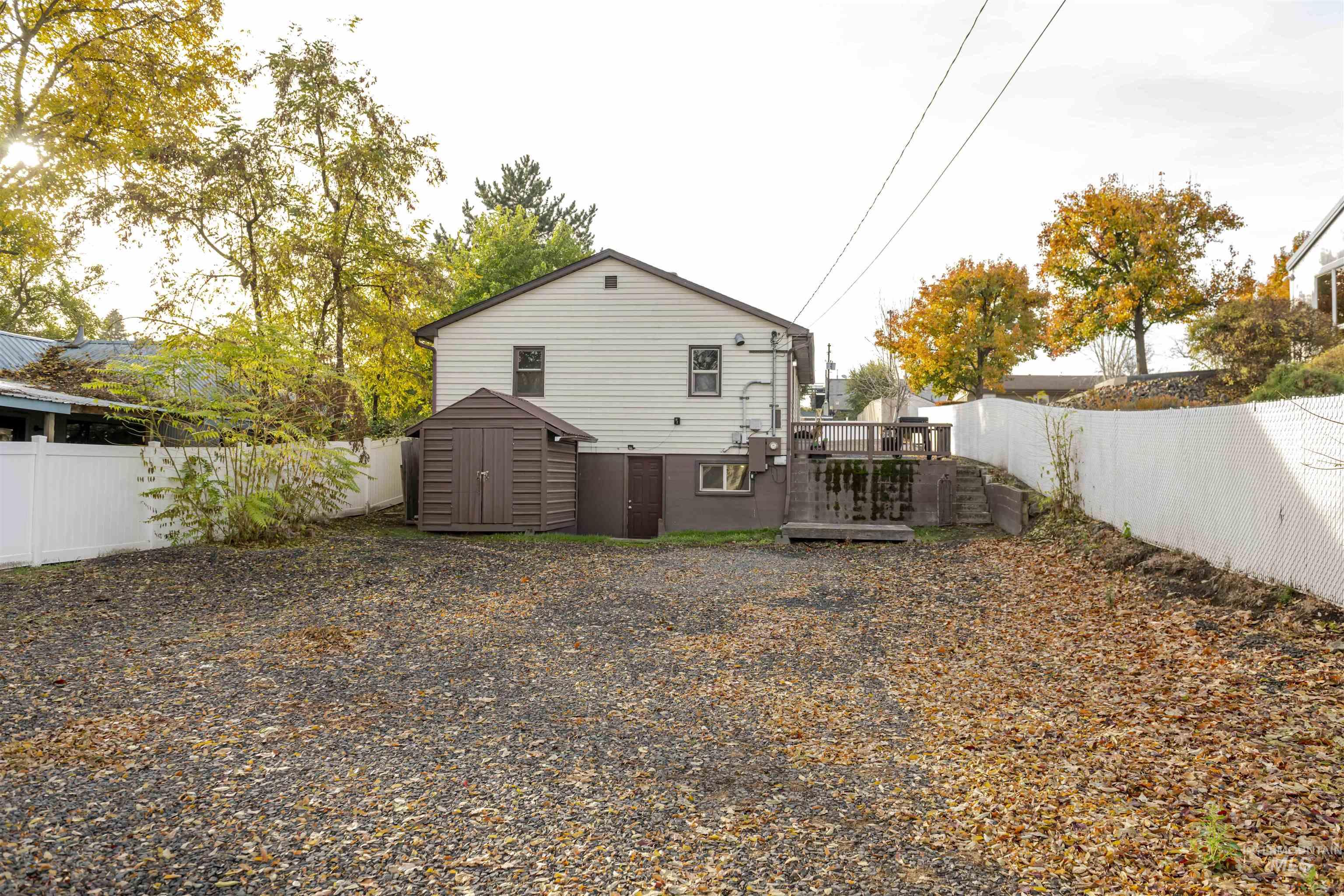 Rear view of property with a fenced backyard, a storage shed, and a deck