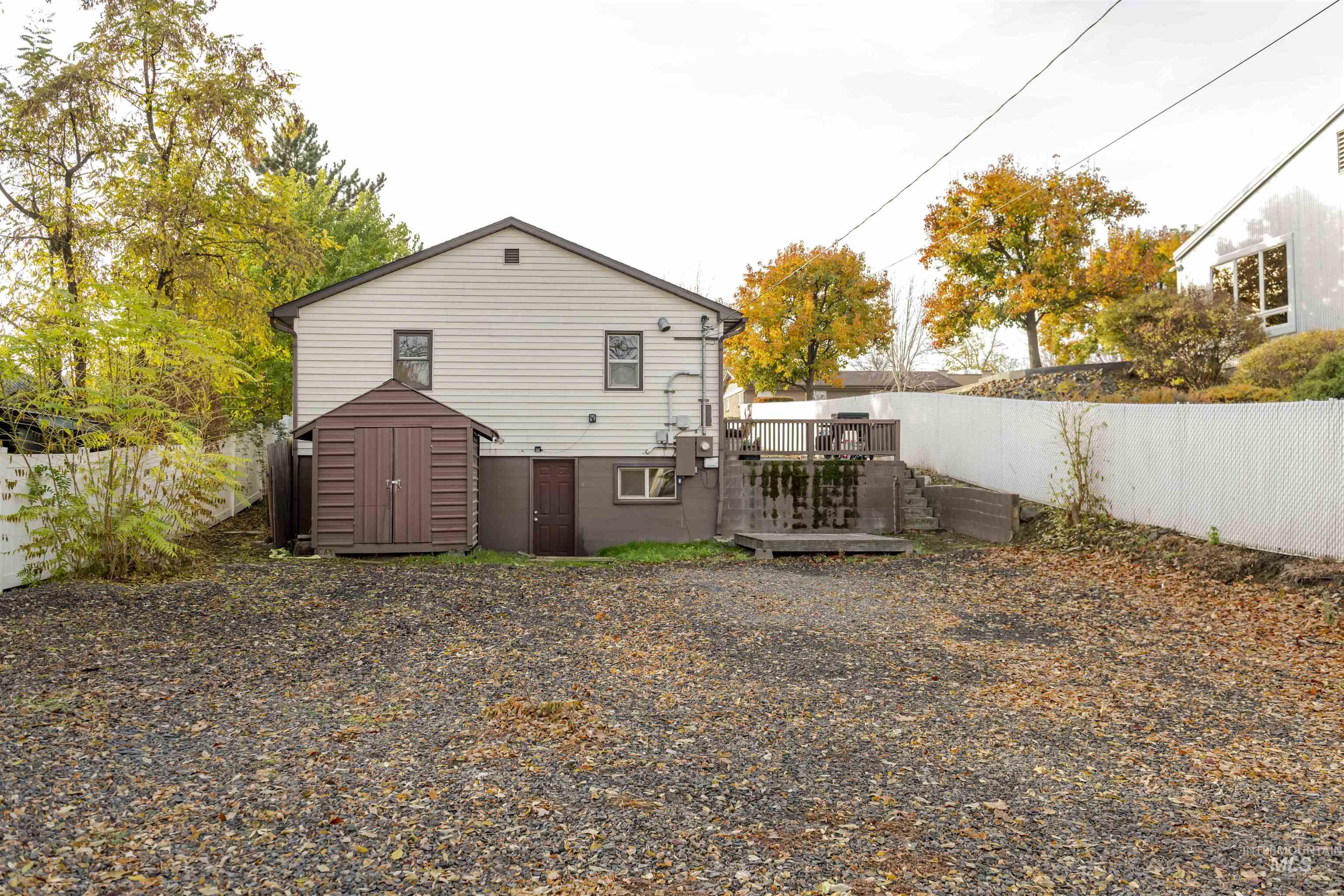 Back of property featuring a storage shed, a deck, and a fenced backyard