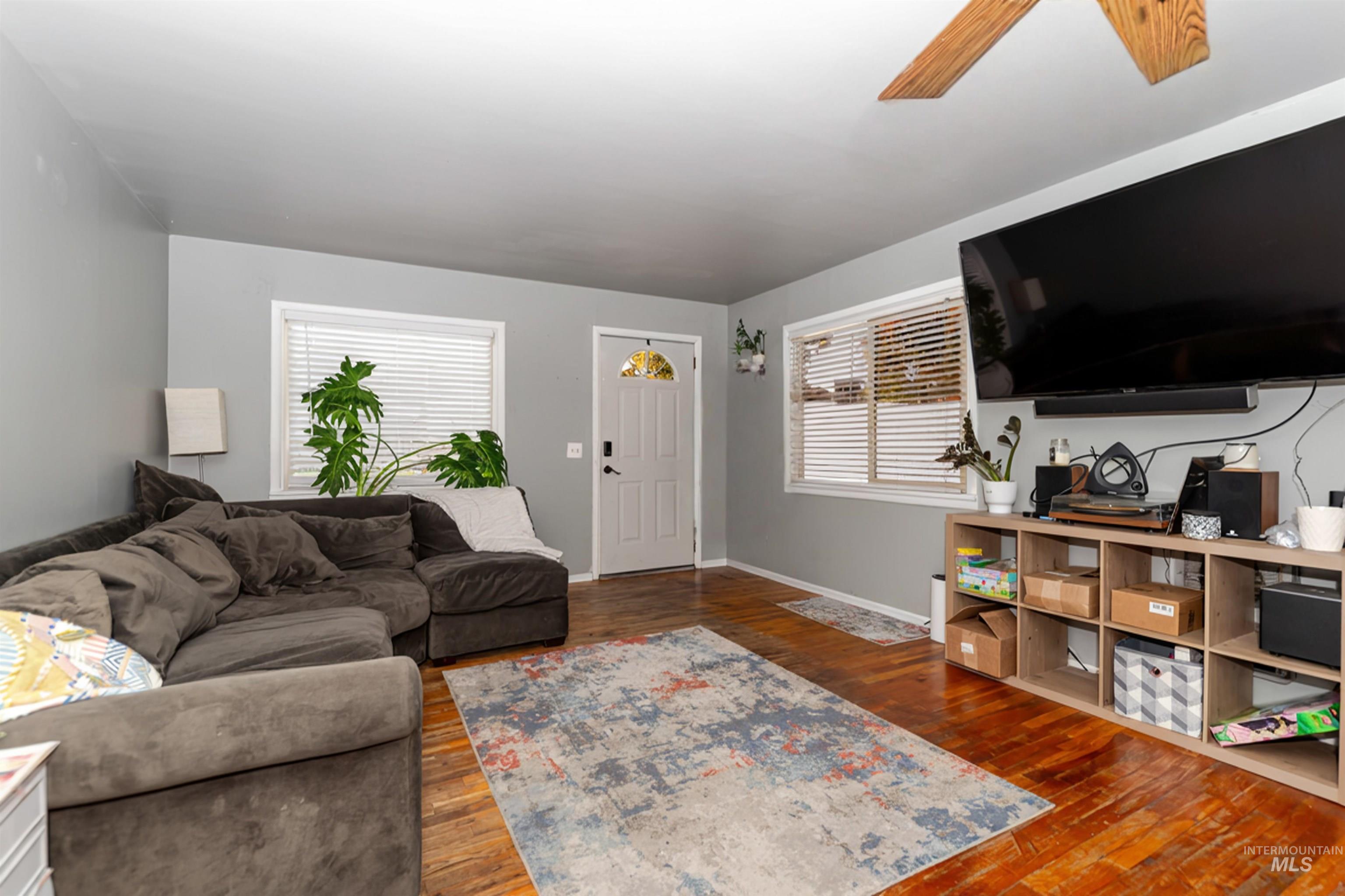Living room featuring dark wood finished floors and a ceiling fan