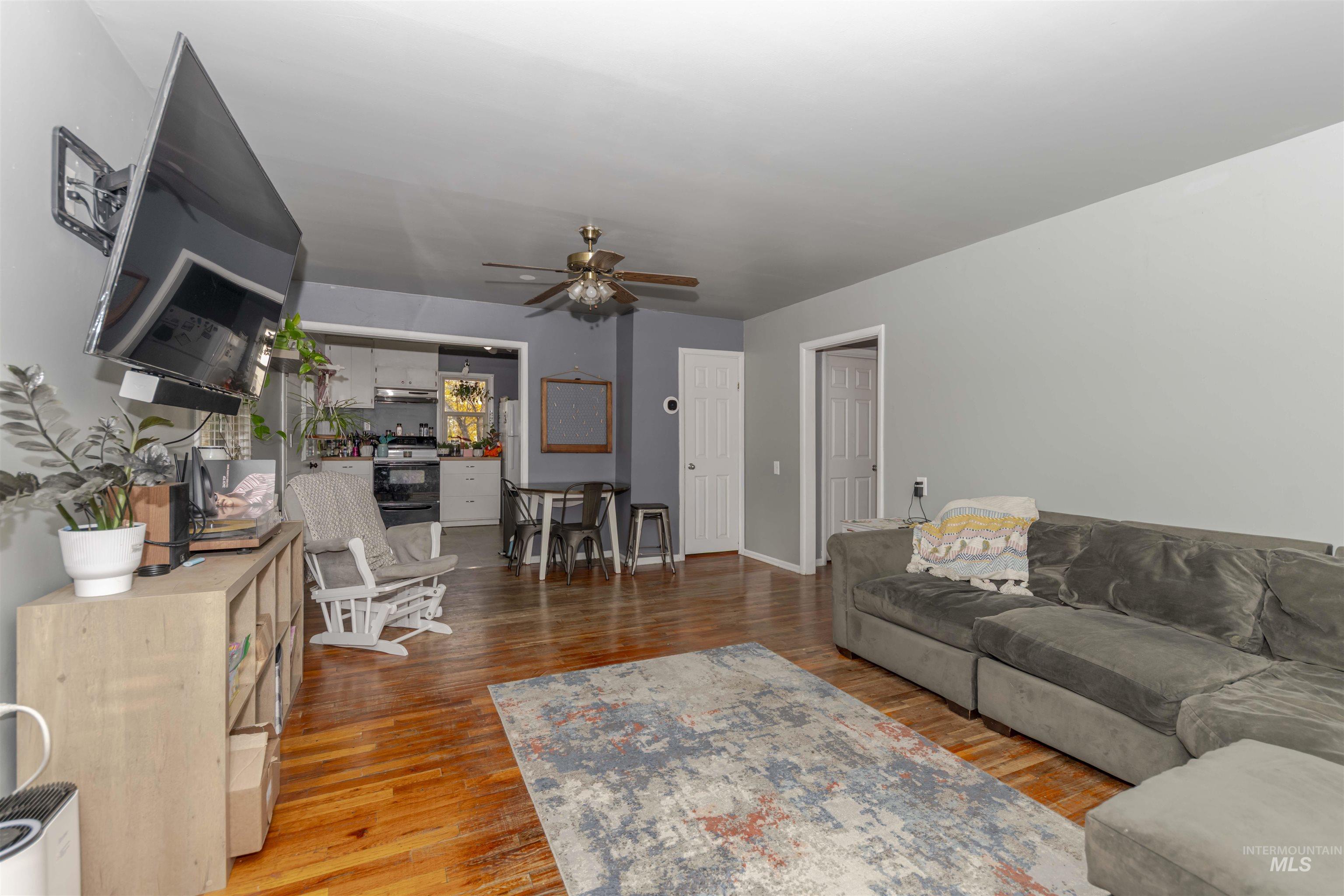 Living area with light wood finished floors and a ceiling fan