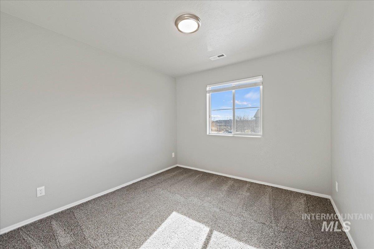 Carpeted empty room with baseboards