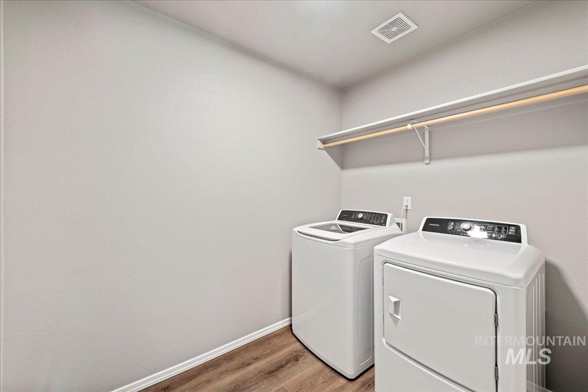 Laundry room featuring wood finished floors and washing machine and dryer