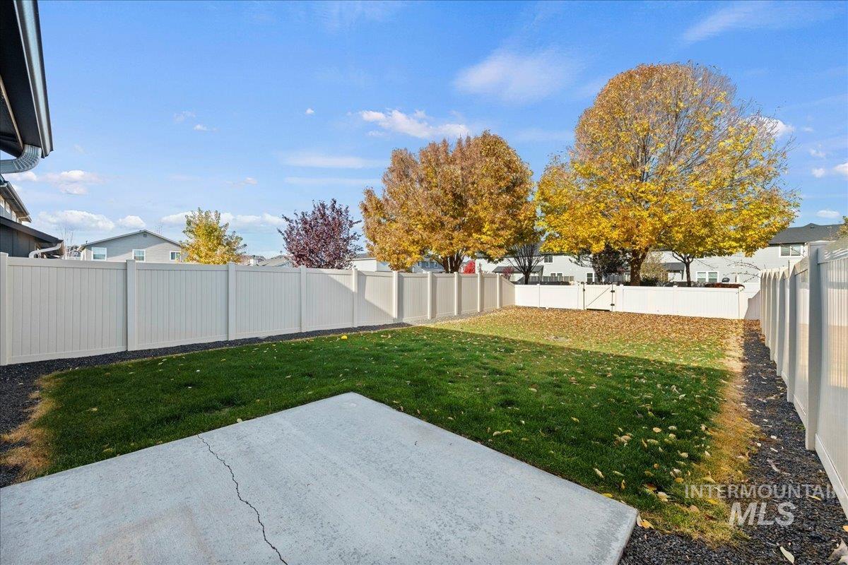 Fenced backyard featuring a patio area and a residential view