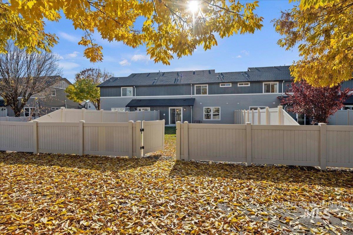 Back of house with a fenced backyard, a gate, and a shingled roof