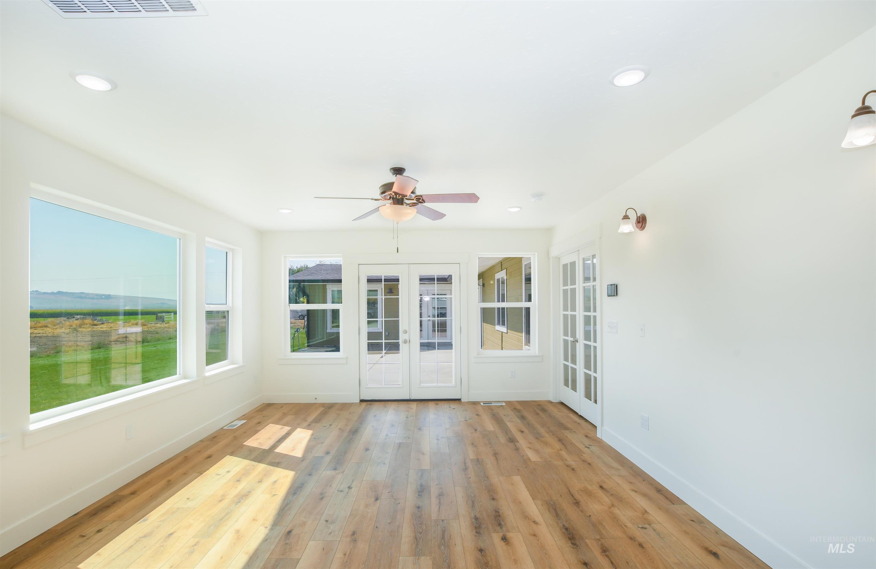 Unfurnished sunroom featuring french doors, wood-type flooring, and recessed lighting
