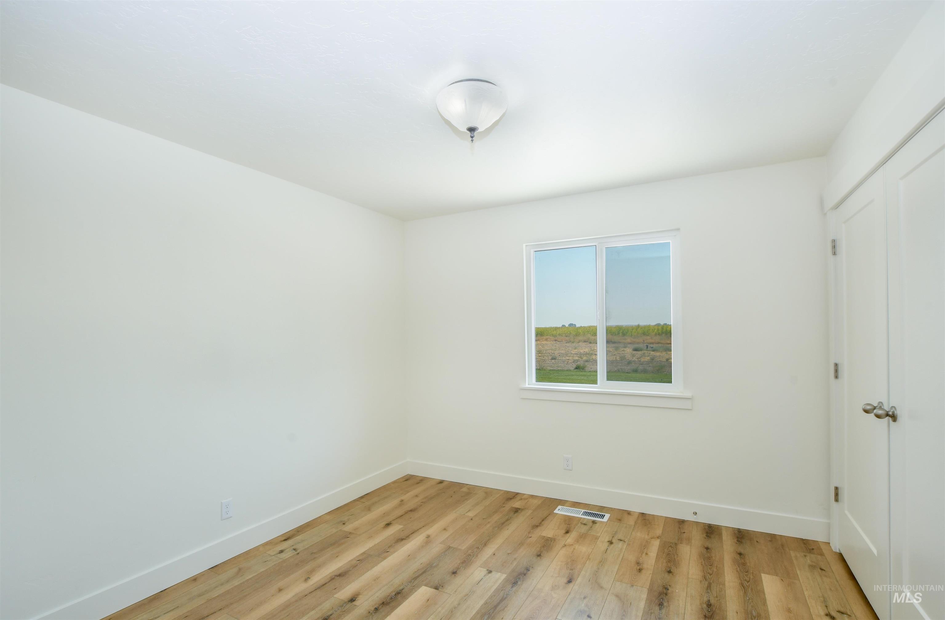 Empty room with light wood finished floors and baseboards
