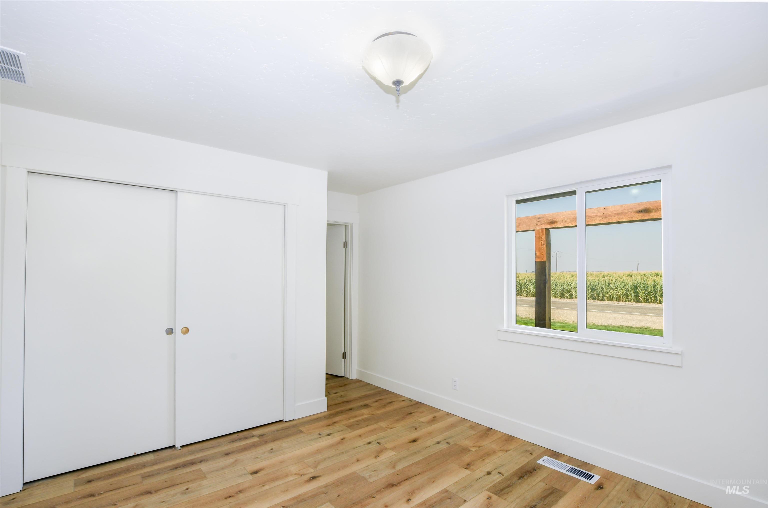 Unfurnished bedroom with light wood finished floors and a closet