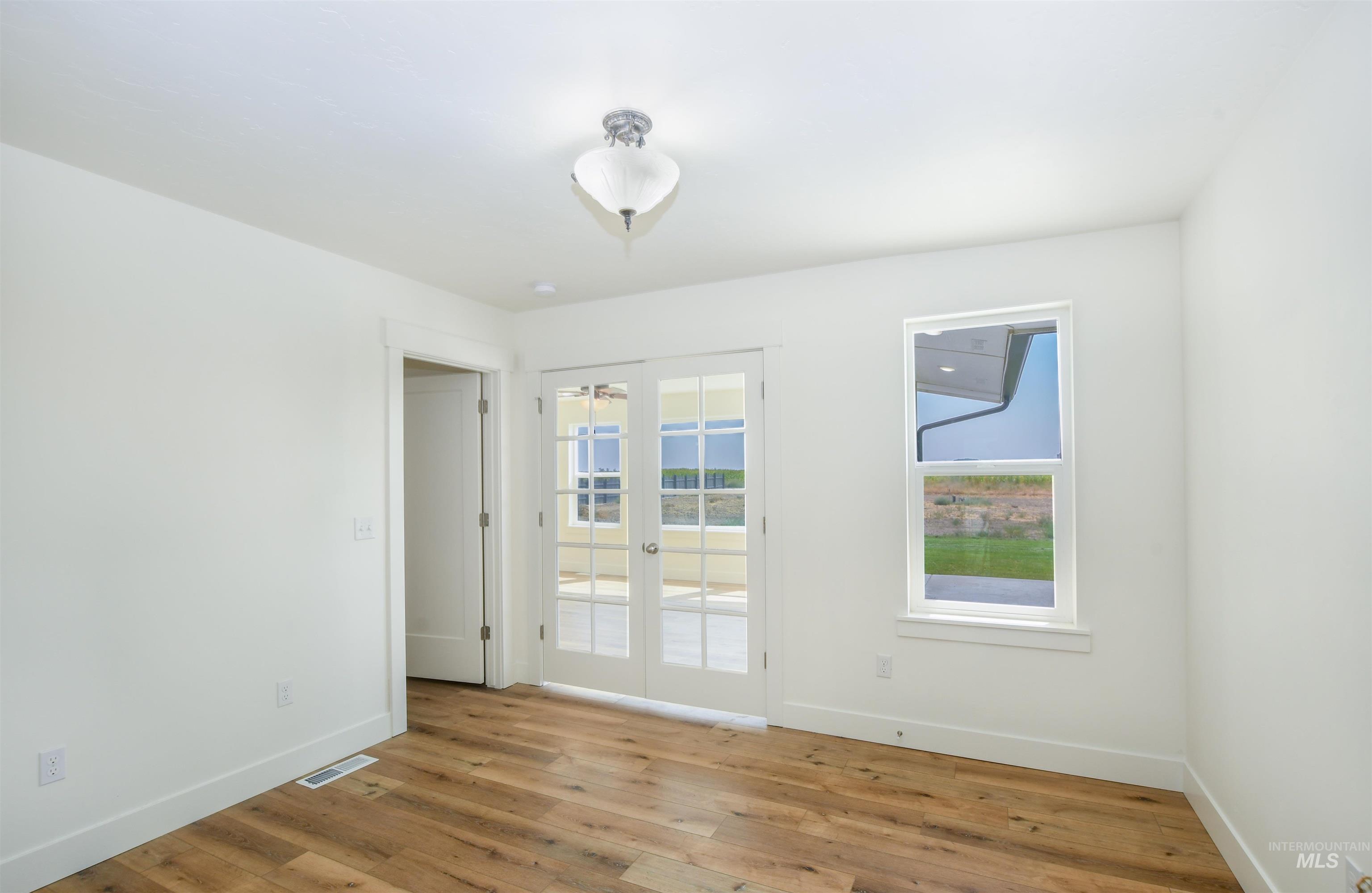 Spare room featuring baseboards and light wood-type flooring