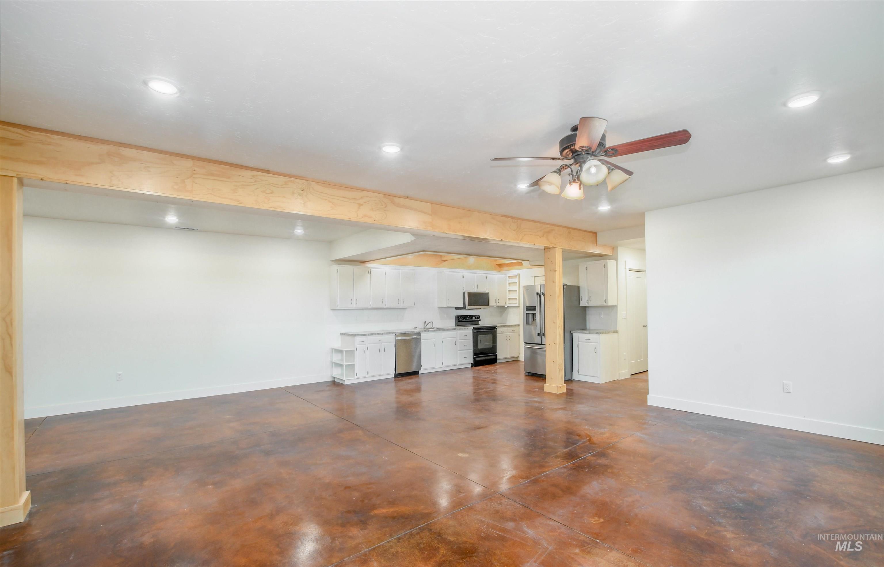 Unfurnished living room featuring concrete floors, ceiling fan, and recessed lighting