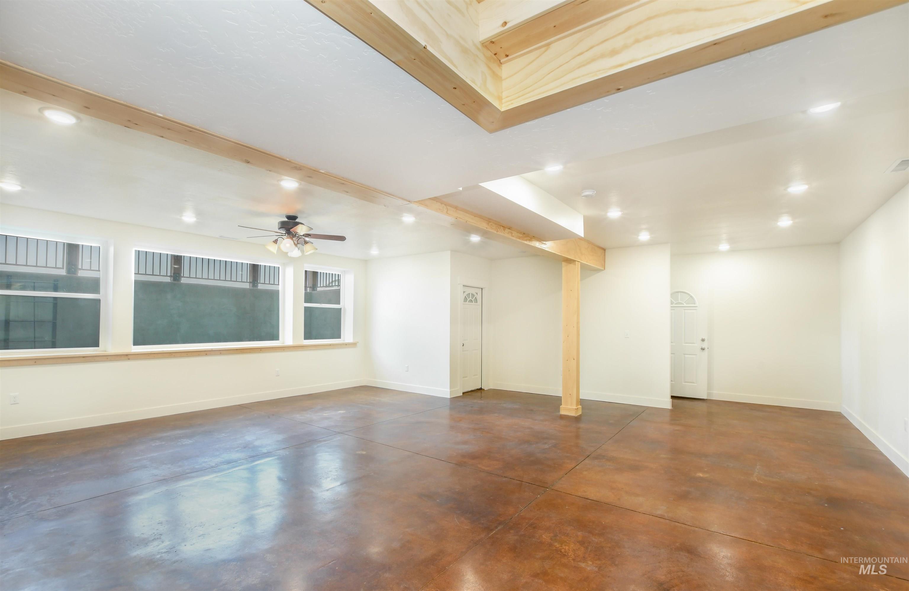 Unfurnished room with recessed lighting, finished concrete flooring, beamed ceiling, and a ceiling fan