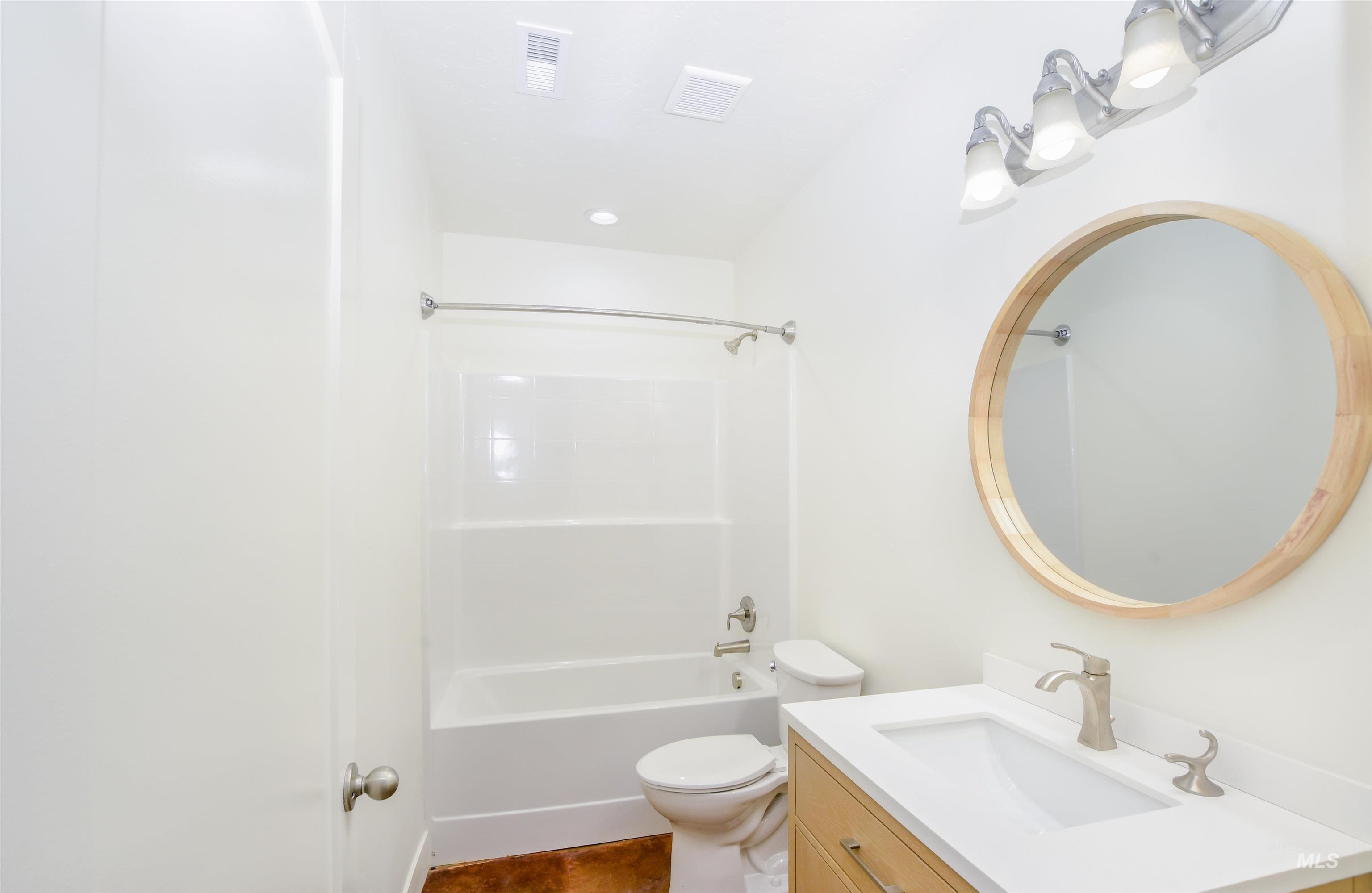 Bathroom with bathing tub / shower combination, vanity, dark tile patterned floors, and recessed lighting