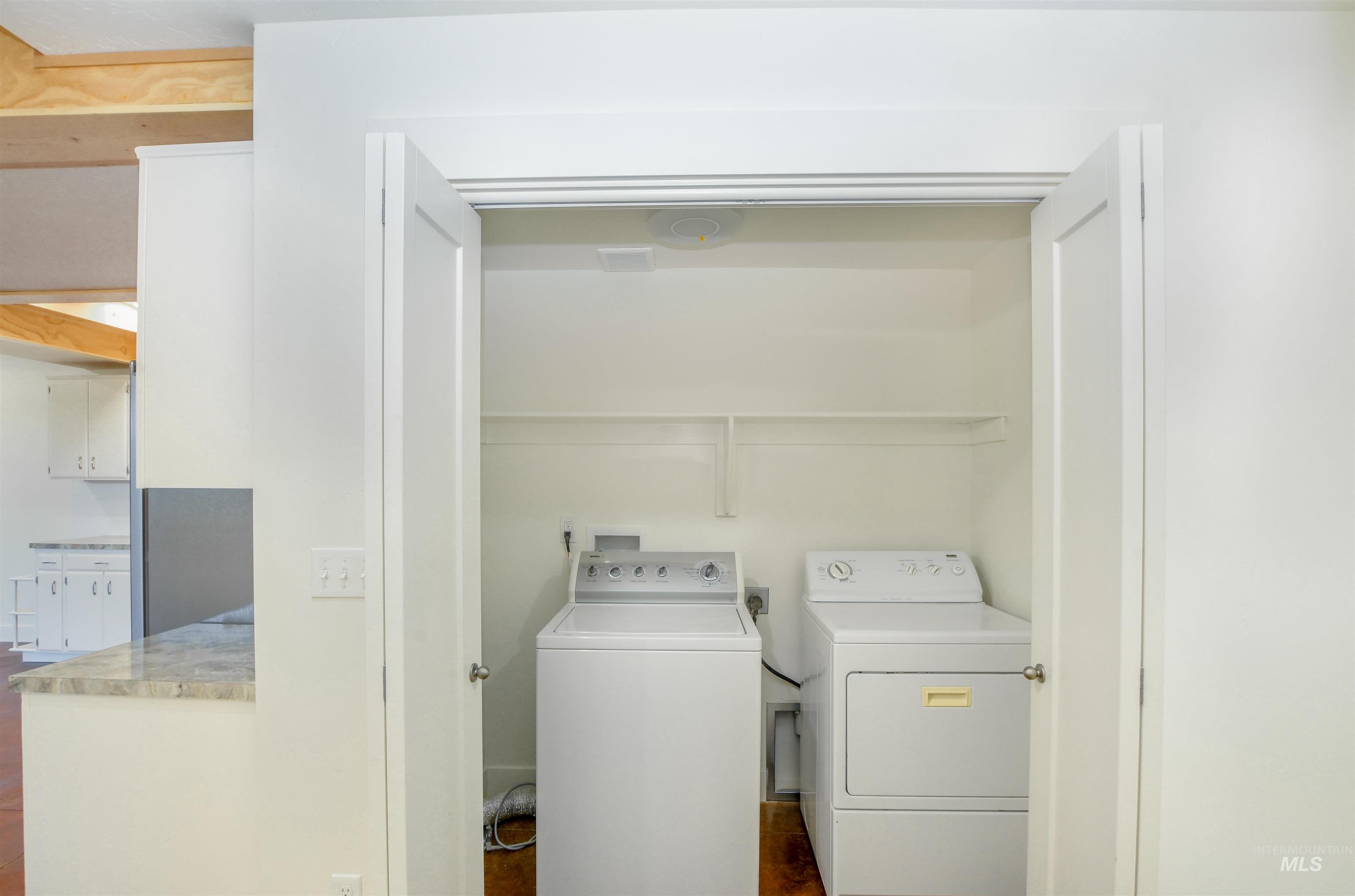 Washroom featuring washer and dryer and dark wood-style flooring