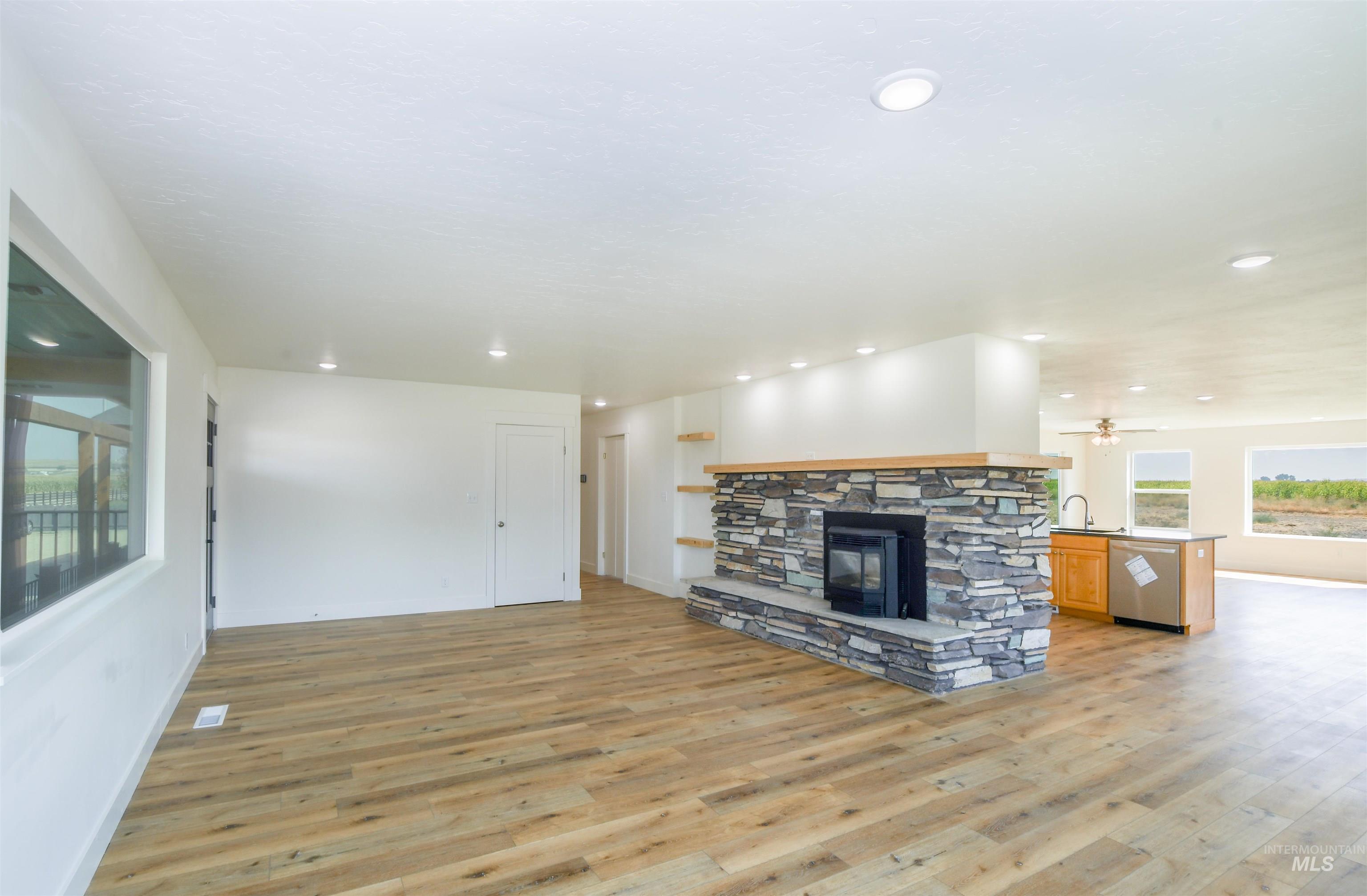Unfurnished living room featuring a fireplace, light wood-style flooring, and recessed lighting
