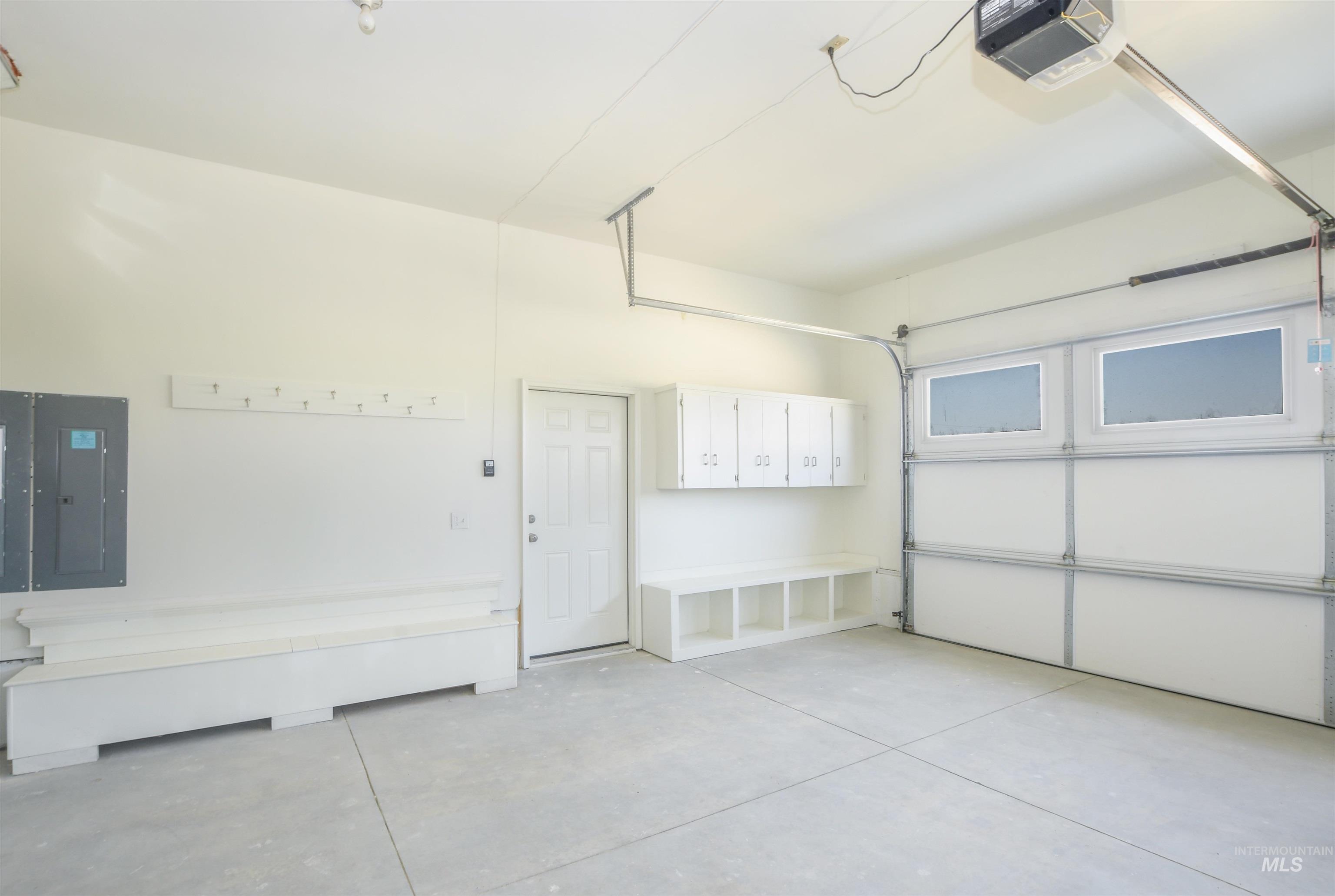 Garage featuring a garage door opener and electric panel