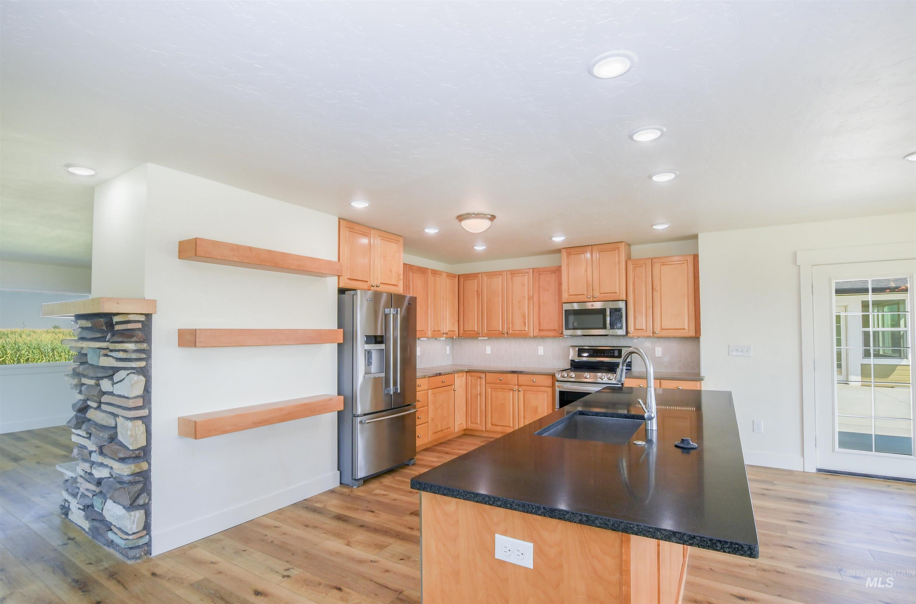 Kitchen featuring healthy amount of natural light, stainless steel appliances, light wood-type flooring, and recessed lighting