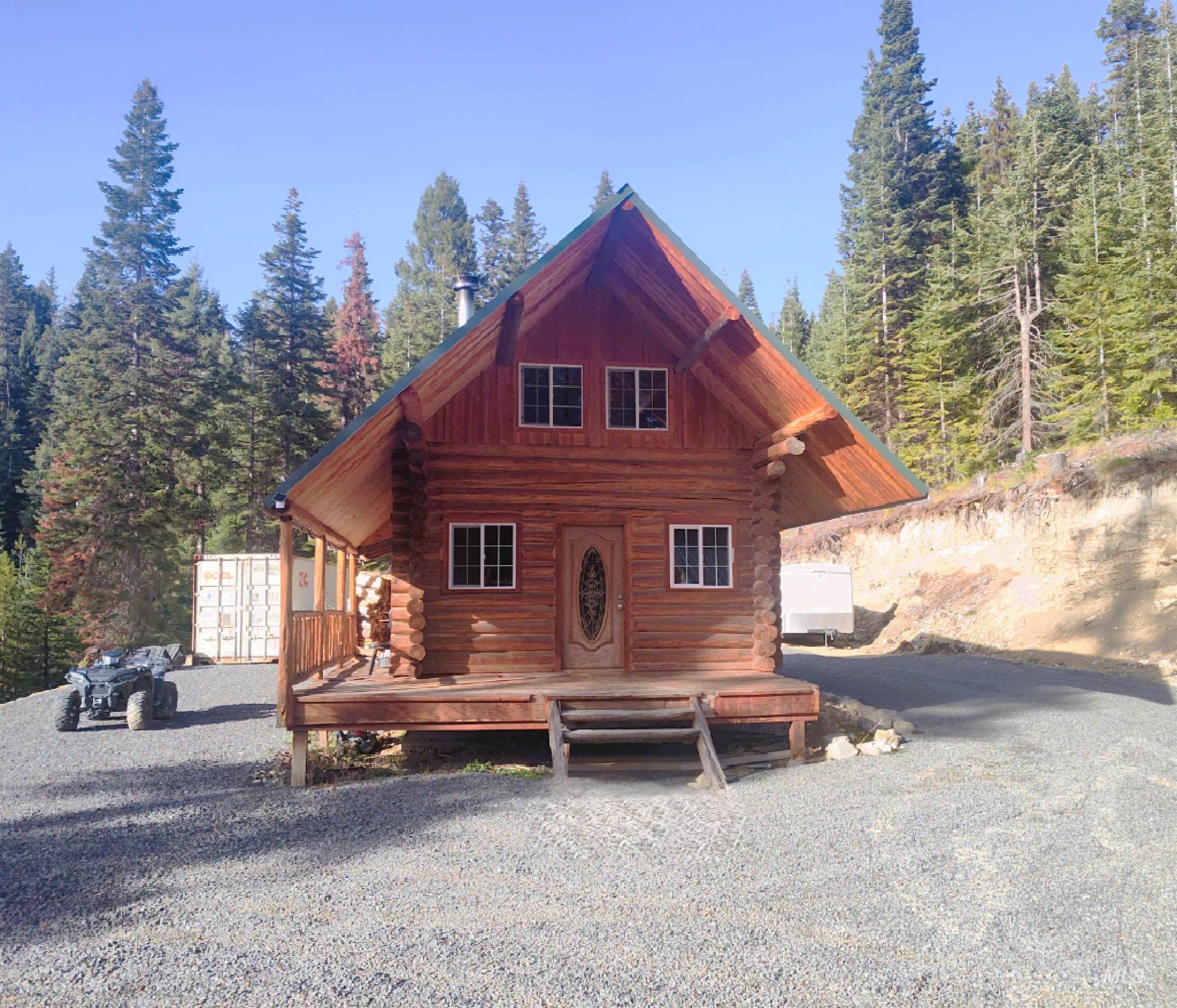 Cabin featuring log siding and a deck