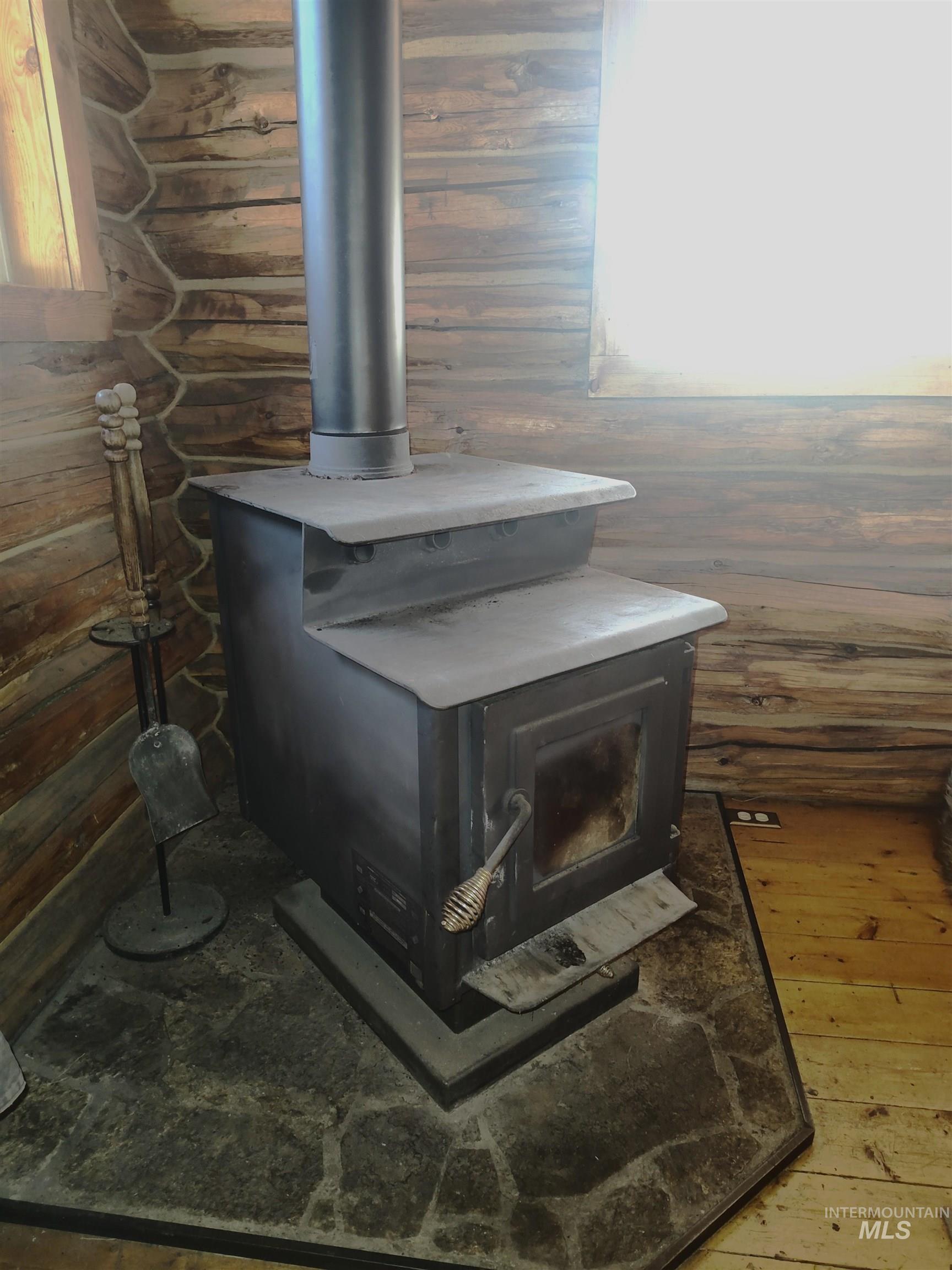 Detailed view of wood finished floors and a wood stove