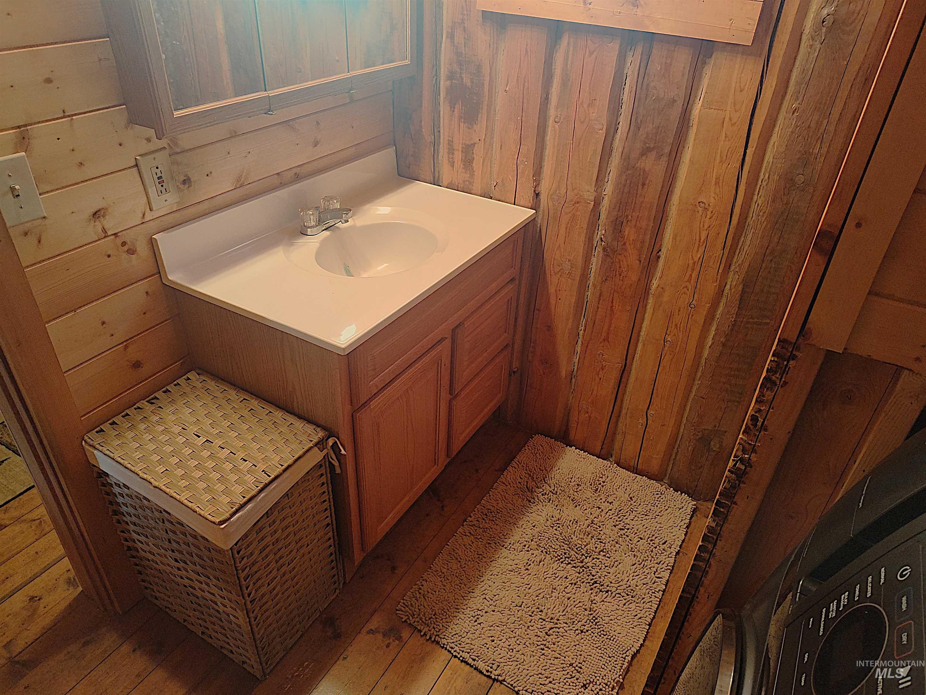 Bathroom with wood walls, vanity, and wood-type flooring