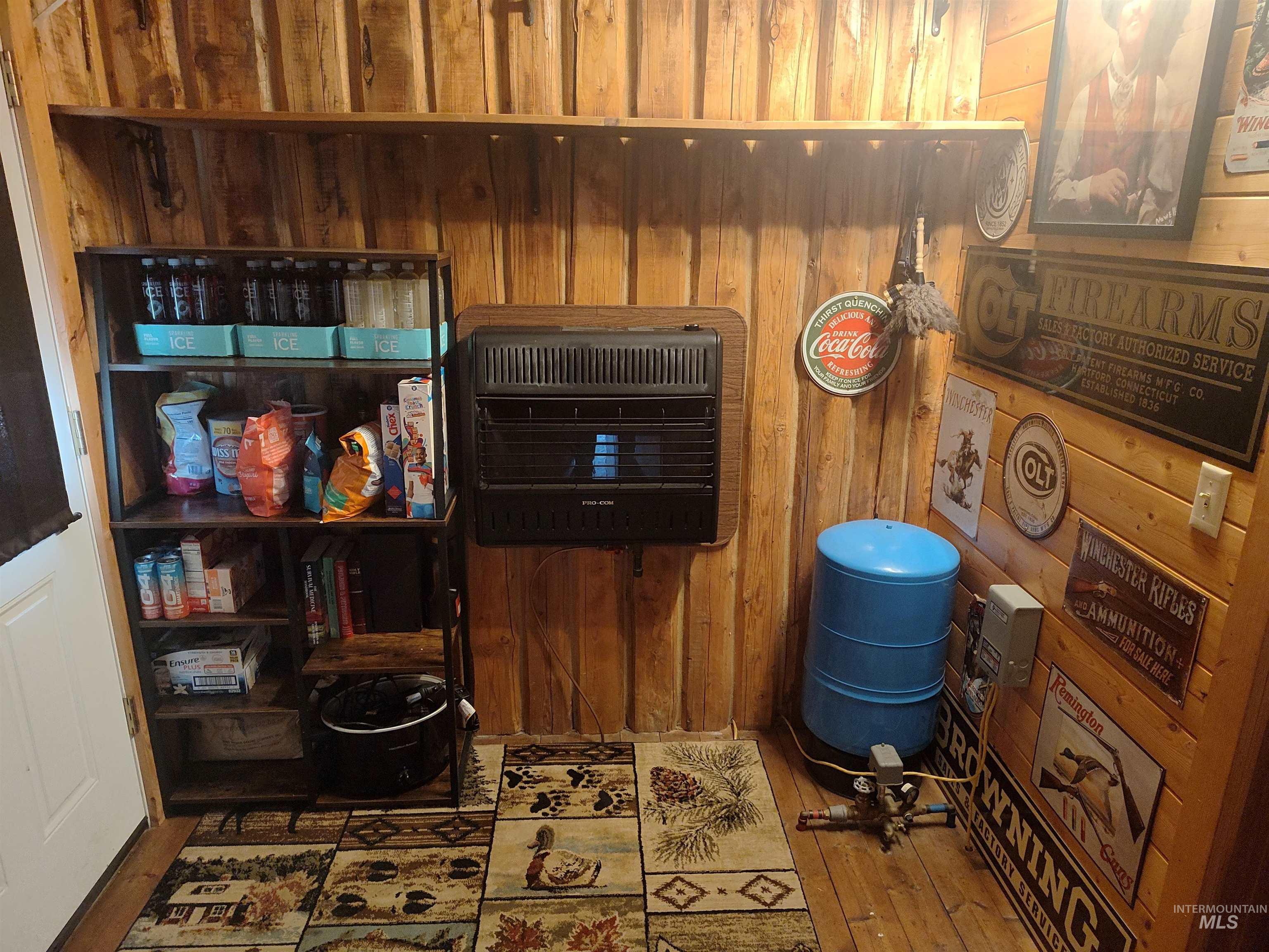 Detailed view of wooden walls, heating unit, a water pressure tank, and wood finished floors
